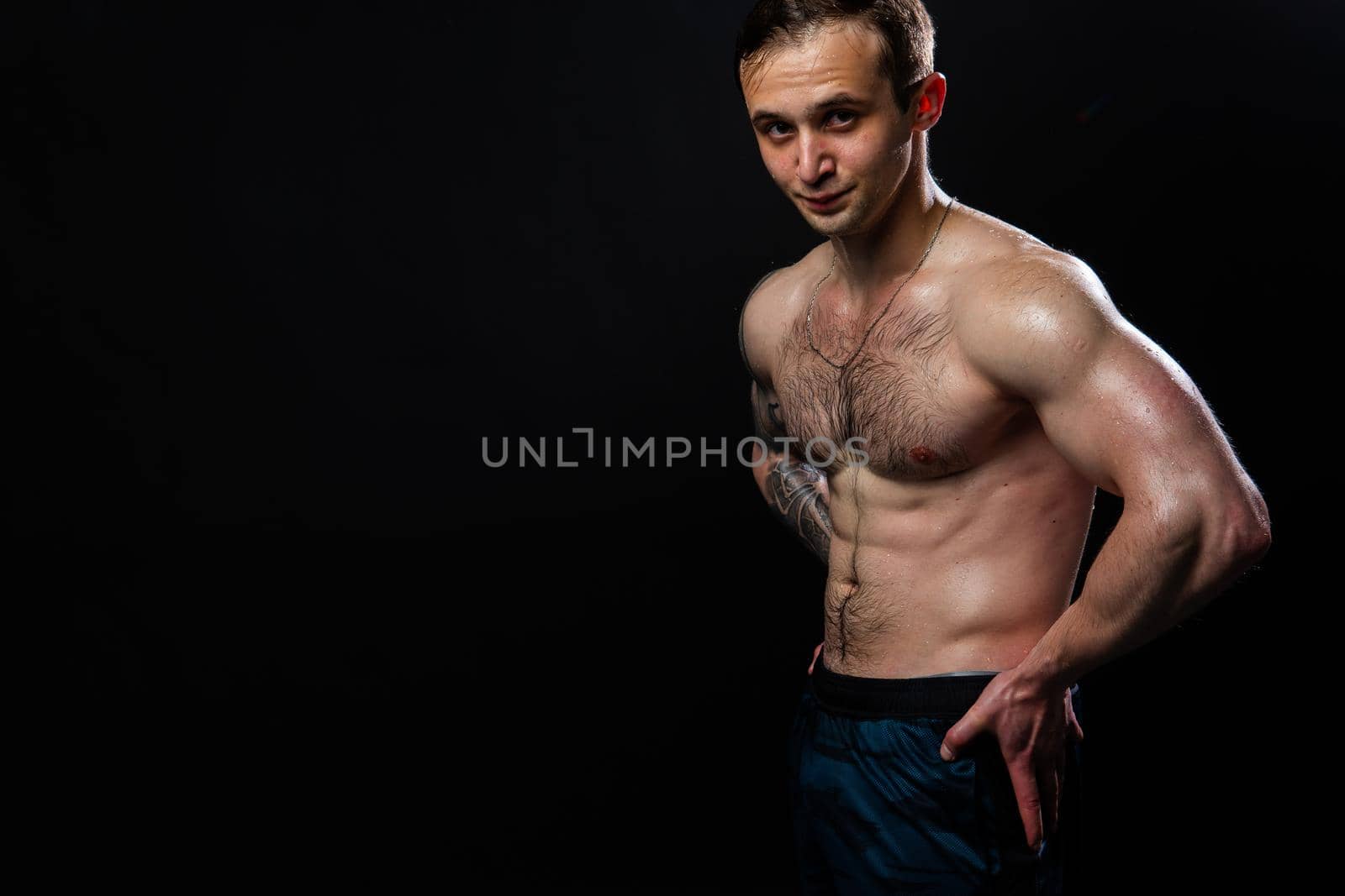 Man on black background keeps dumbbells pumped up in fitness chest sport, man lifting hand, healthy pectoral. Lift power, guy fit hands behind your back, press tense beautiful body