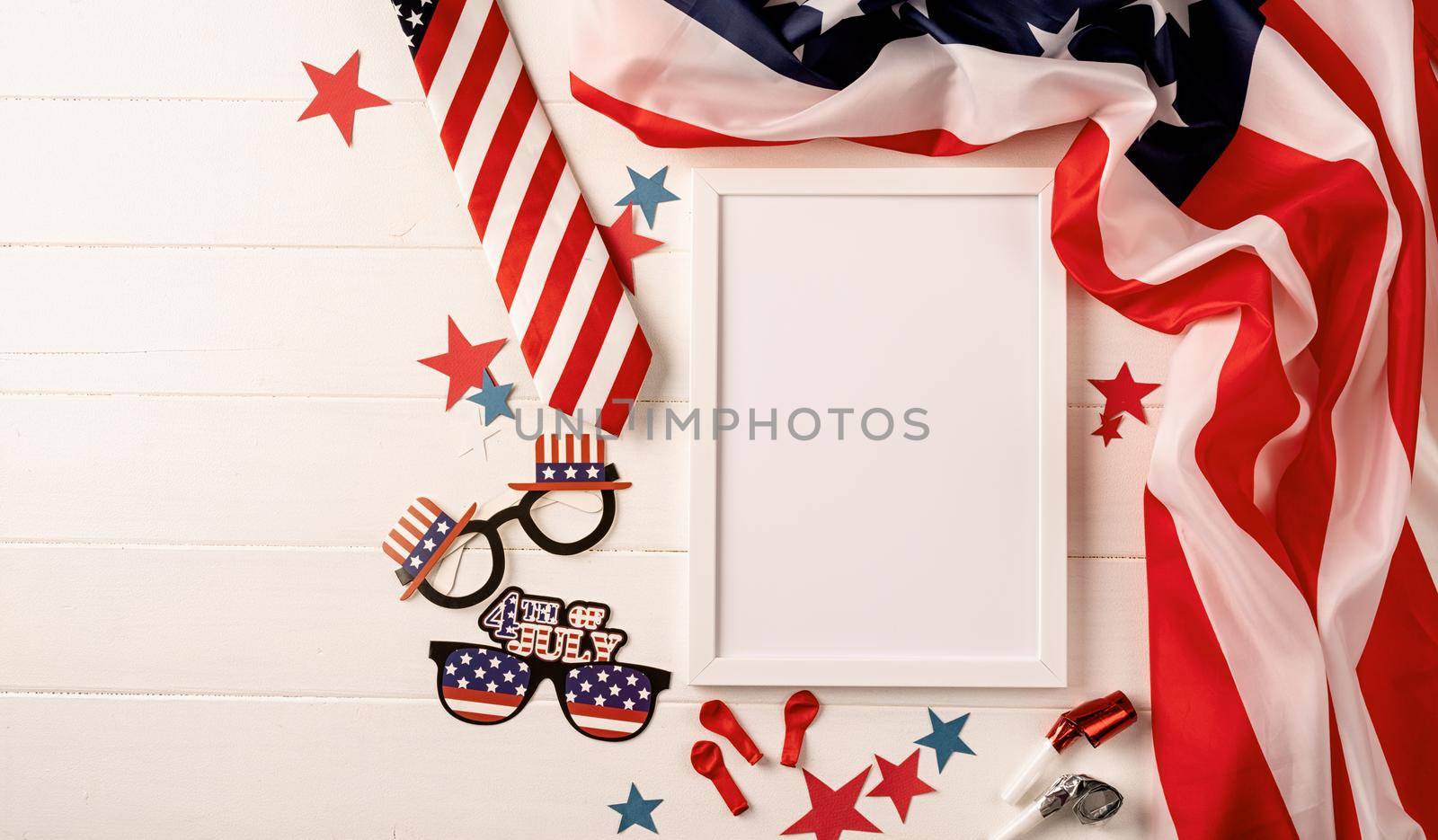 Blank white photo frame for mockup design on American national flag wooden background with decorations by Desperada
