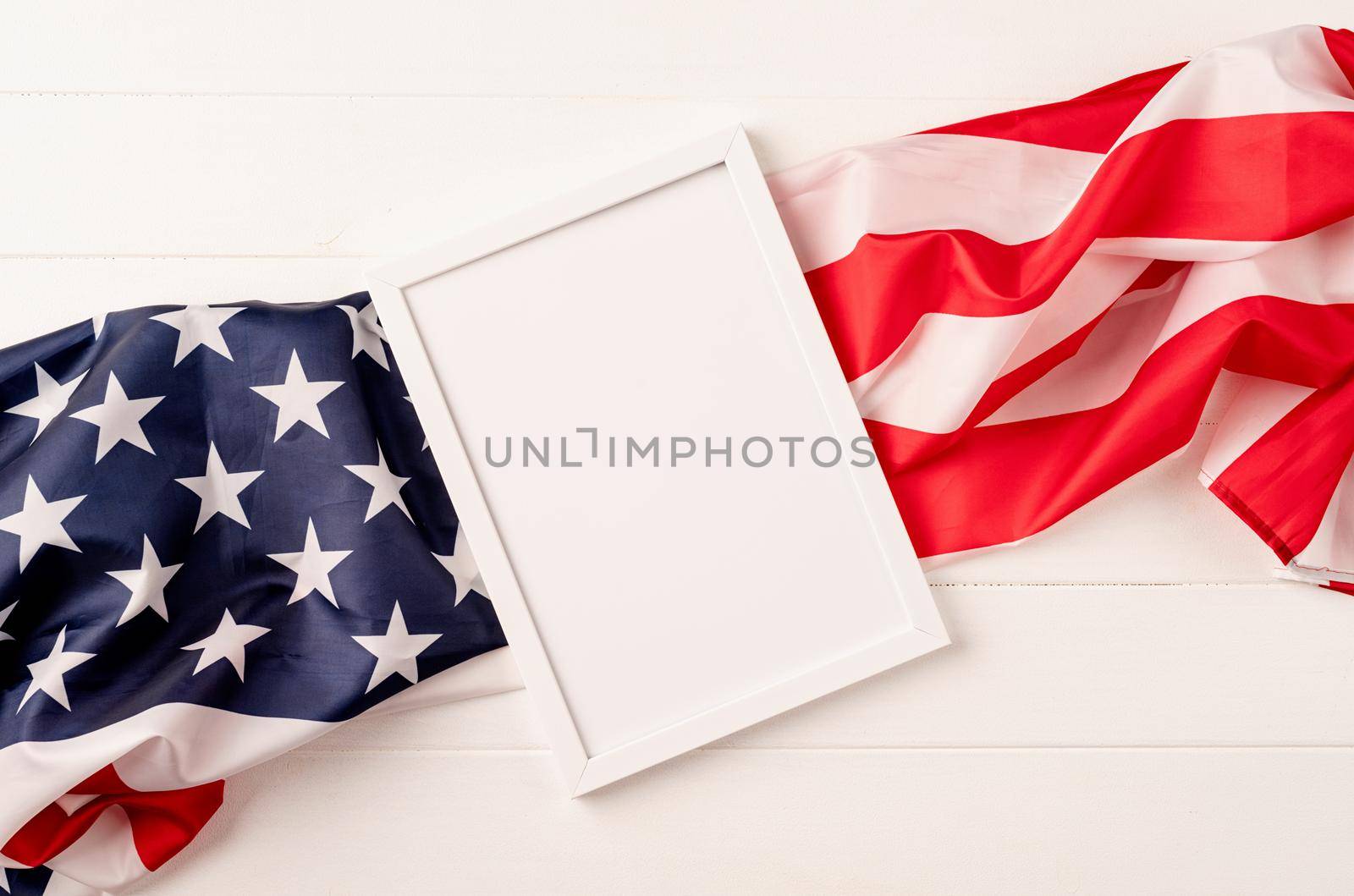 Blank white photo frame for mockup design on American national flag wooden background by Desperada