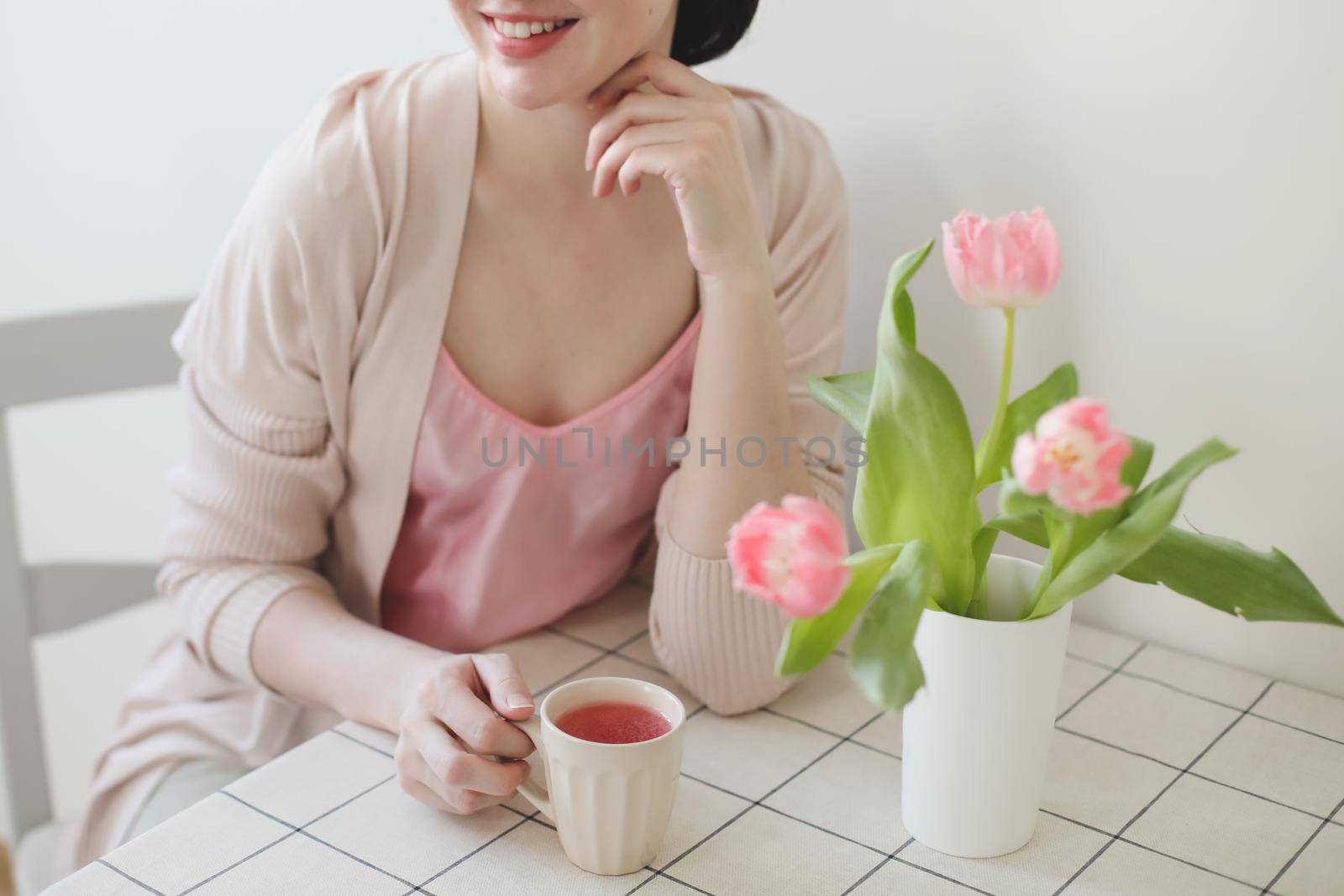 romantic spring portrait of a young woman with tulips at home.