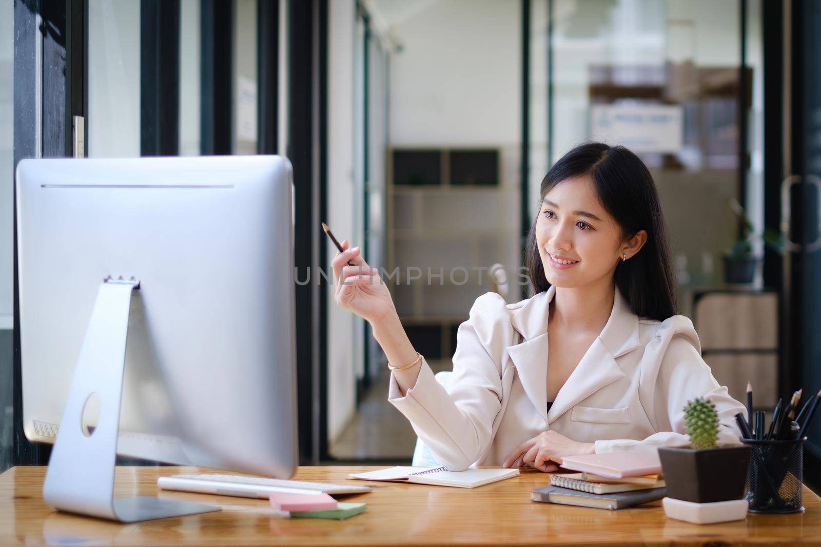 Asian Woman blogger wear white suit talking with followers, live streaming on social media application. Freelance work from home concept