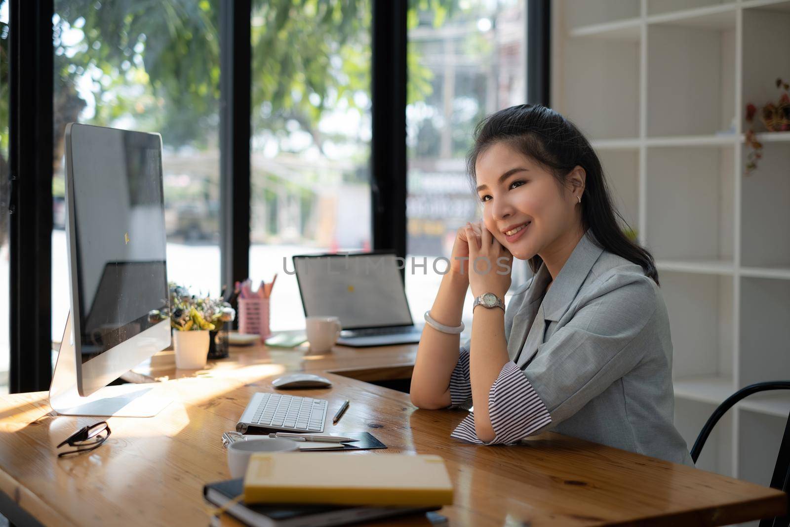 Asian business woman having video call with business team to consult about business plan of company. Online team meeting video conference. by itchaznong