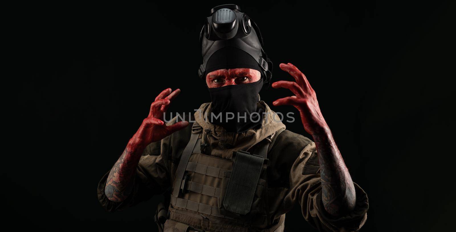 photo of a man in a military uniform and balaclava with a bloody face and hands up to the elbow in blood on a black background by Rotozey