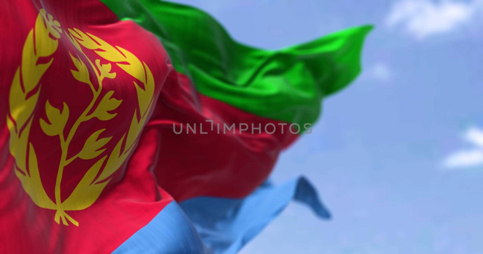 Detail of the national flag of Eritrea waving in the wind on a clear day. Eritrea is a country in the Horn of Africa region of Eastern Africa. Selective focus.