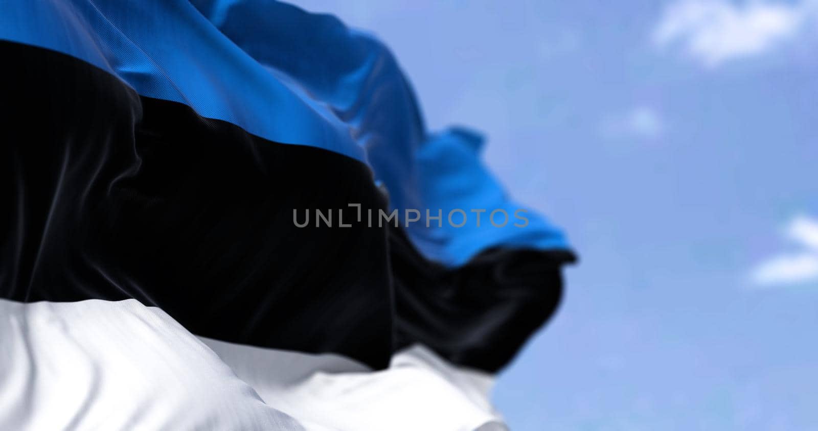 Detail of the national flag of Estonia waving in the wind on a clear day. Estonia is a country in northern Europe. Selective focus.