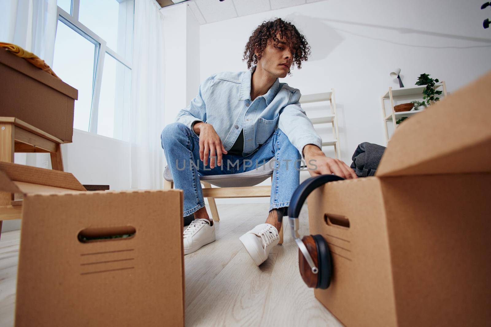 portrait of a man sitting on a chair with boxes moving Lifestyle. High quality photo