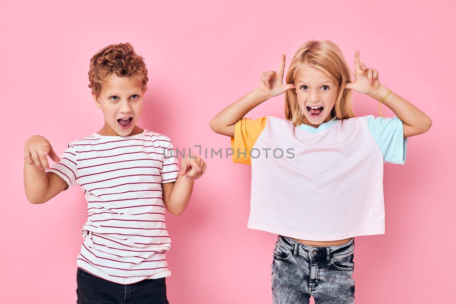 boy and girl fun antics pink background. High quality photo