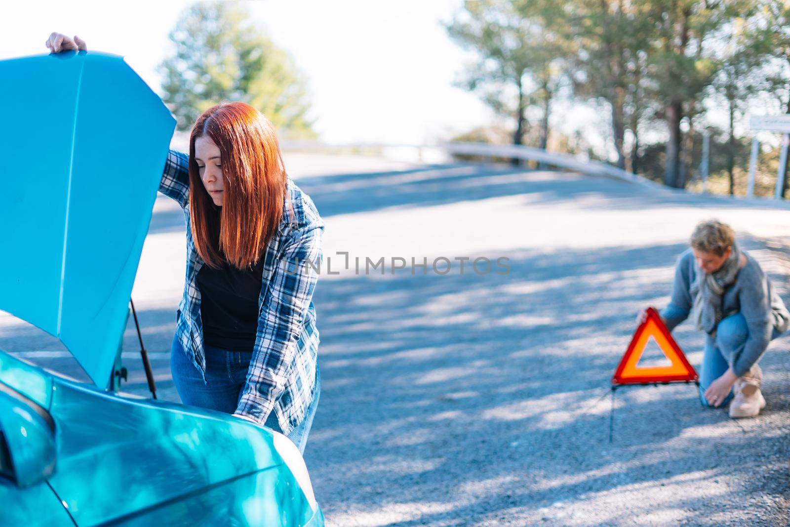 general shot of two women with the broken down car by CatPhotography