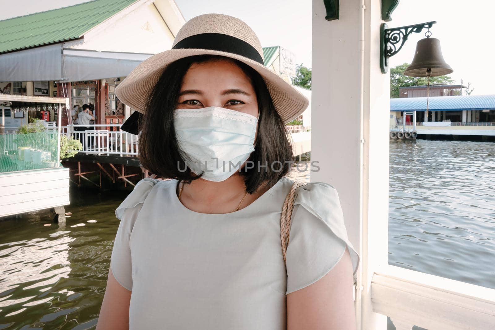 Smile Tourist Woman Having Fun While Sightseeing Bangkok Cityscape beside The River, Portrait of Happy Smiling Tourist Woman in Wearing Face Mask During New Normal Covid-19 Situation. Travel Concept