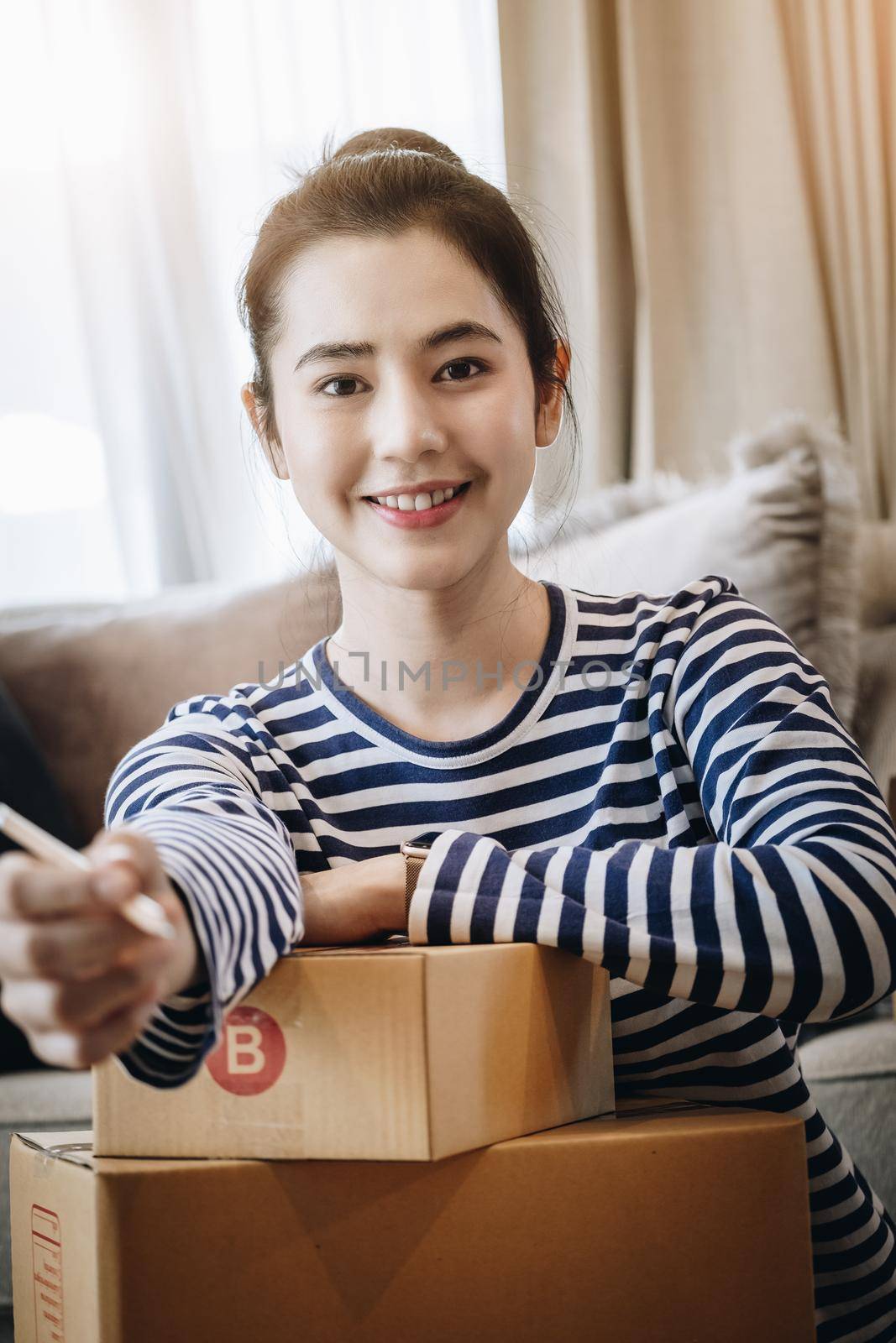 Online selling business idea, beautiful girl smiling happily from selling products online from home. by Manastrong