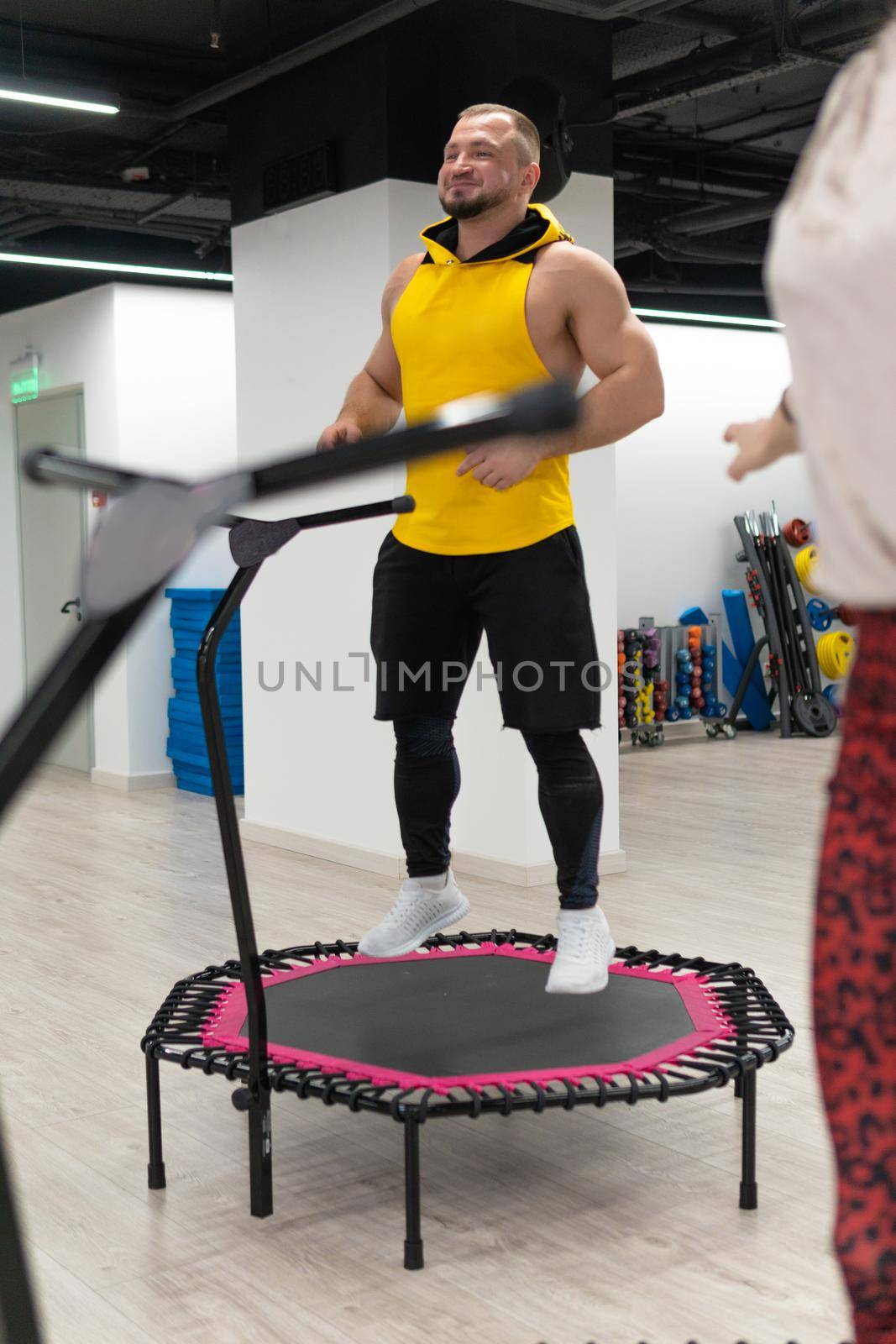 Women's and men's group on a sports trampoline, fitness training, healthy life - a concept trampoline group batut girl men, for female athletic from training from teamwork motion, smiling happiness. Studio bodycare indoor, colored