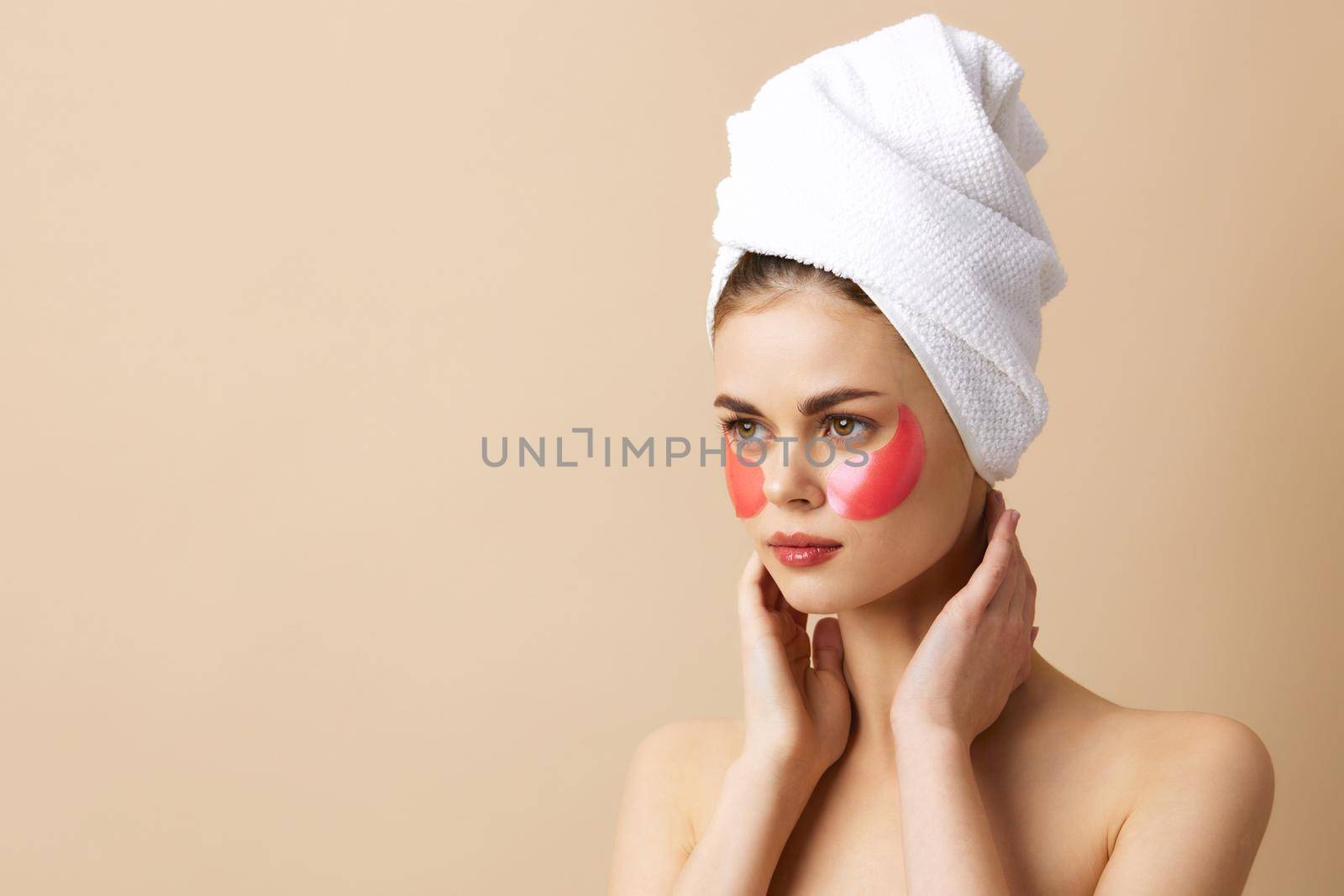 portrait woman pink patches on the face with a towel on the head beige background by SHOTPRIME