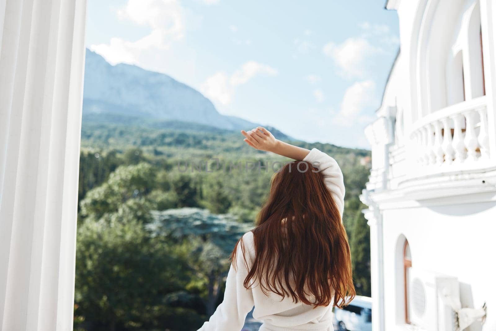 beautiful woman looks at a beautiful view from the balcony Mountain View. High quality photo