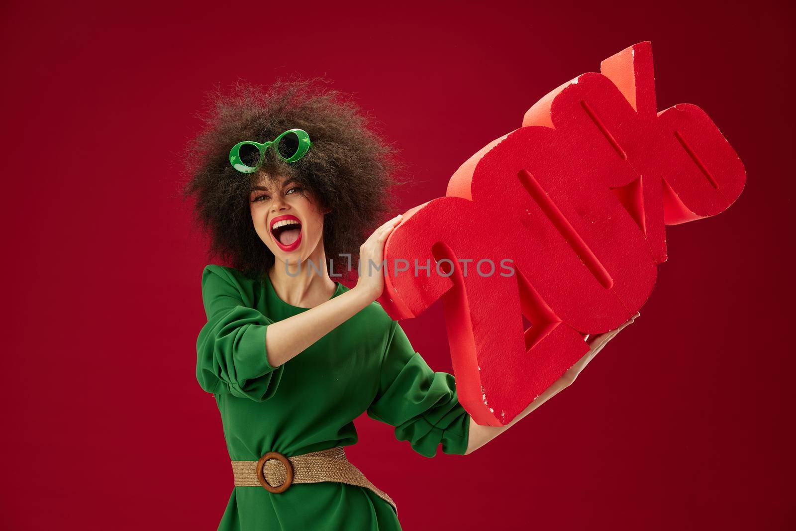 Beautiful fashionable girl green dress afro hairstyle dark glasses twenty percent in hands studio model unaltered by SHOTPRIME