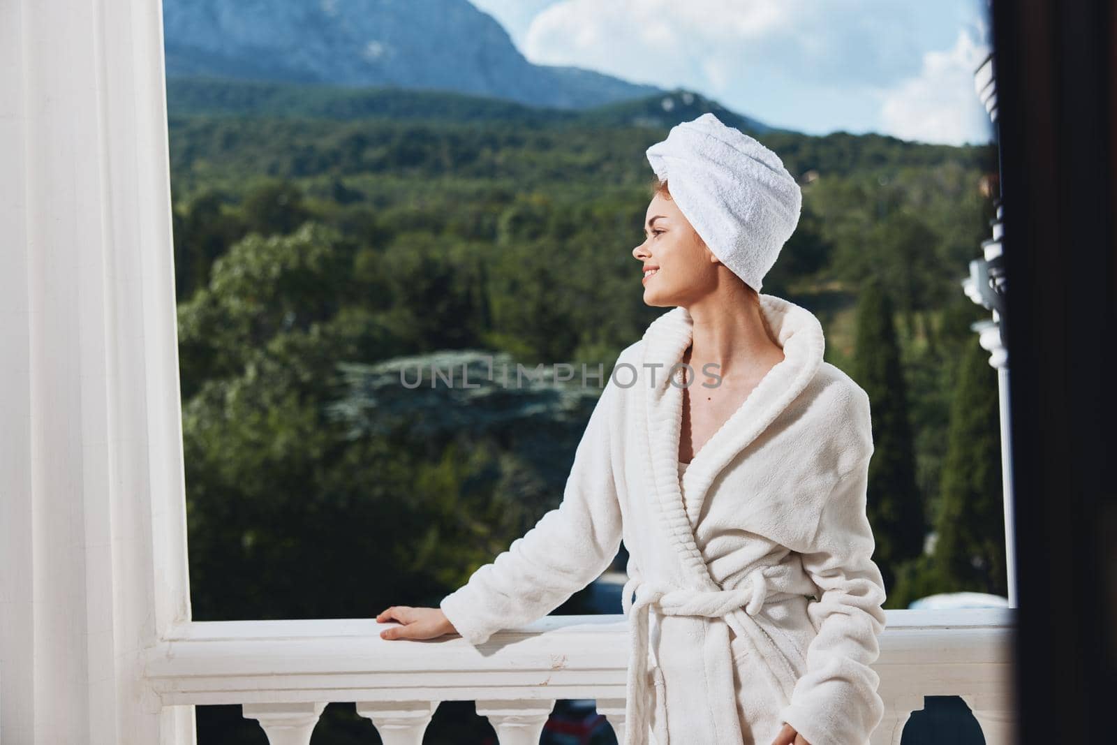 Attractive young woman posing against the backdrop of mountains on the balcony architecture Perfect sunny morning. High quality photo