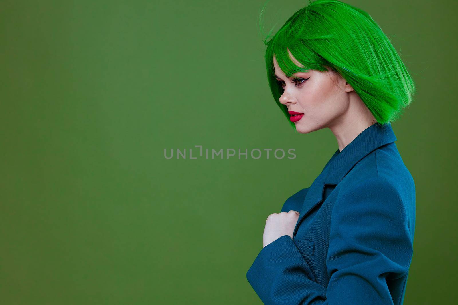 Beauty Fashion woman attractive look green wig blue jacket posing studio model unaltered. High quality photo