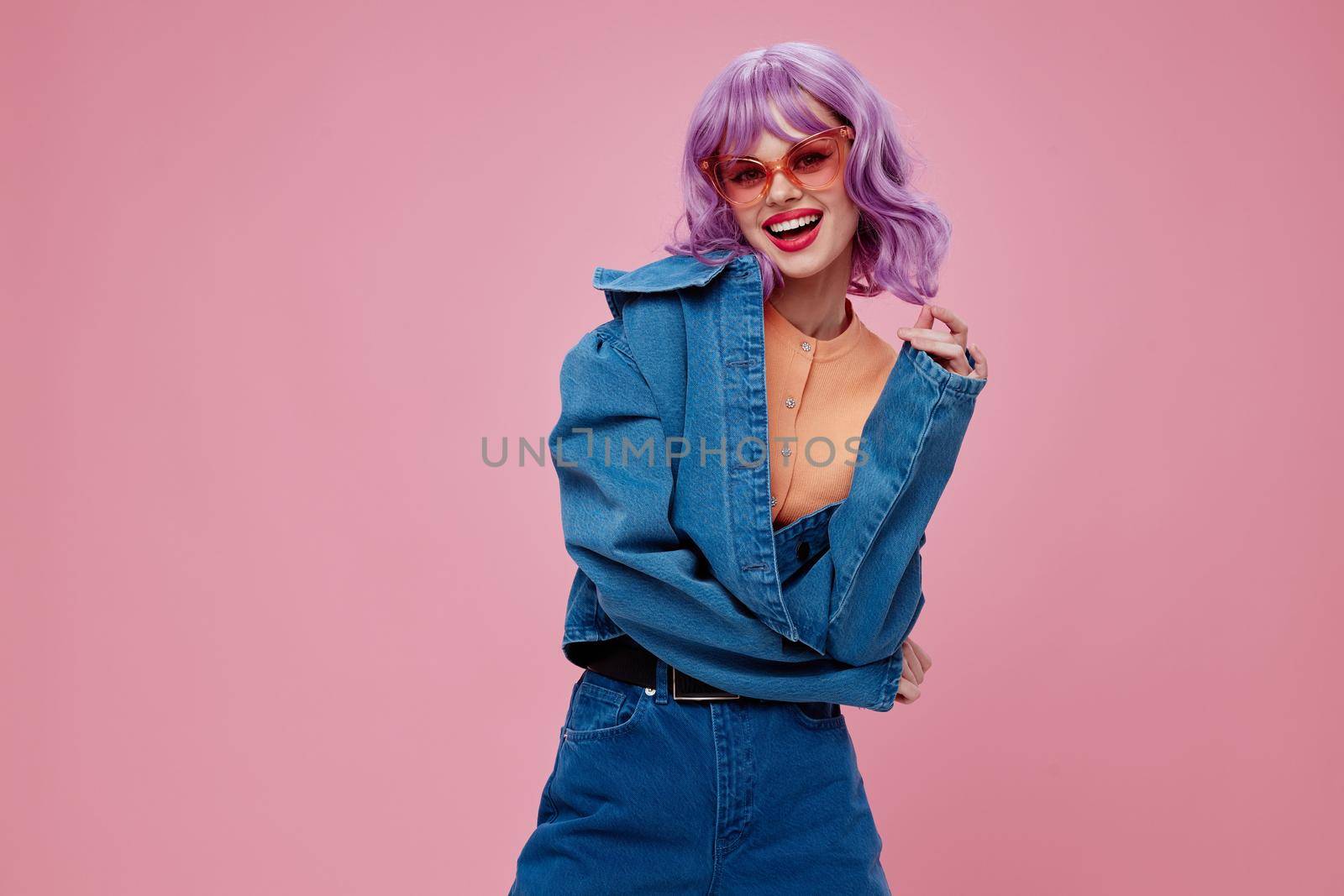 Positive young woman purple hair fashion glasses denim clothing color background unaltered. High quality photo