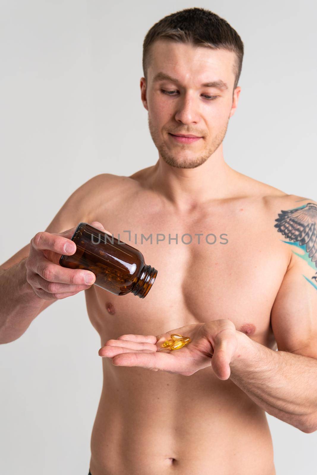 Fish oil is eaten by a man in the hands of vials and a glass bottle supplement, medicine treatment medical cure lifestyle, young closeup. translucent, background female giving dieting