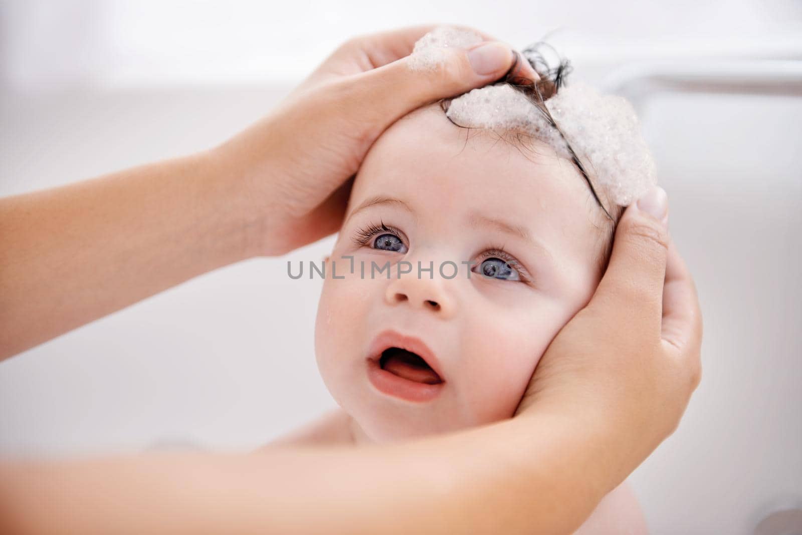 Cropped shot of a mother washing her baby boys hair.
