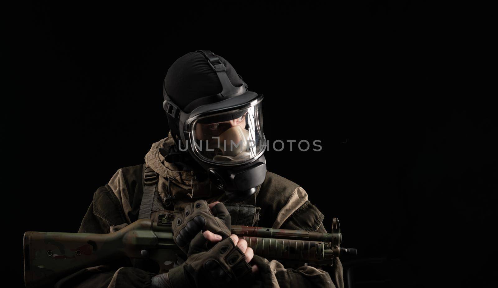 man in a military uniform and a gas mask holds a weapon with an angry expression of emotion