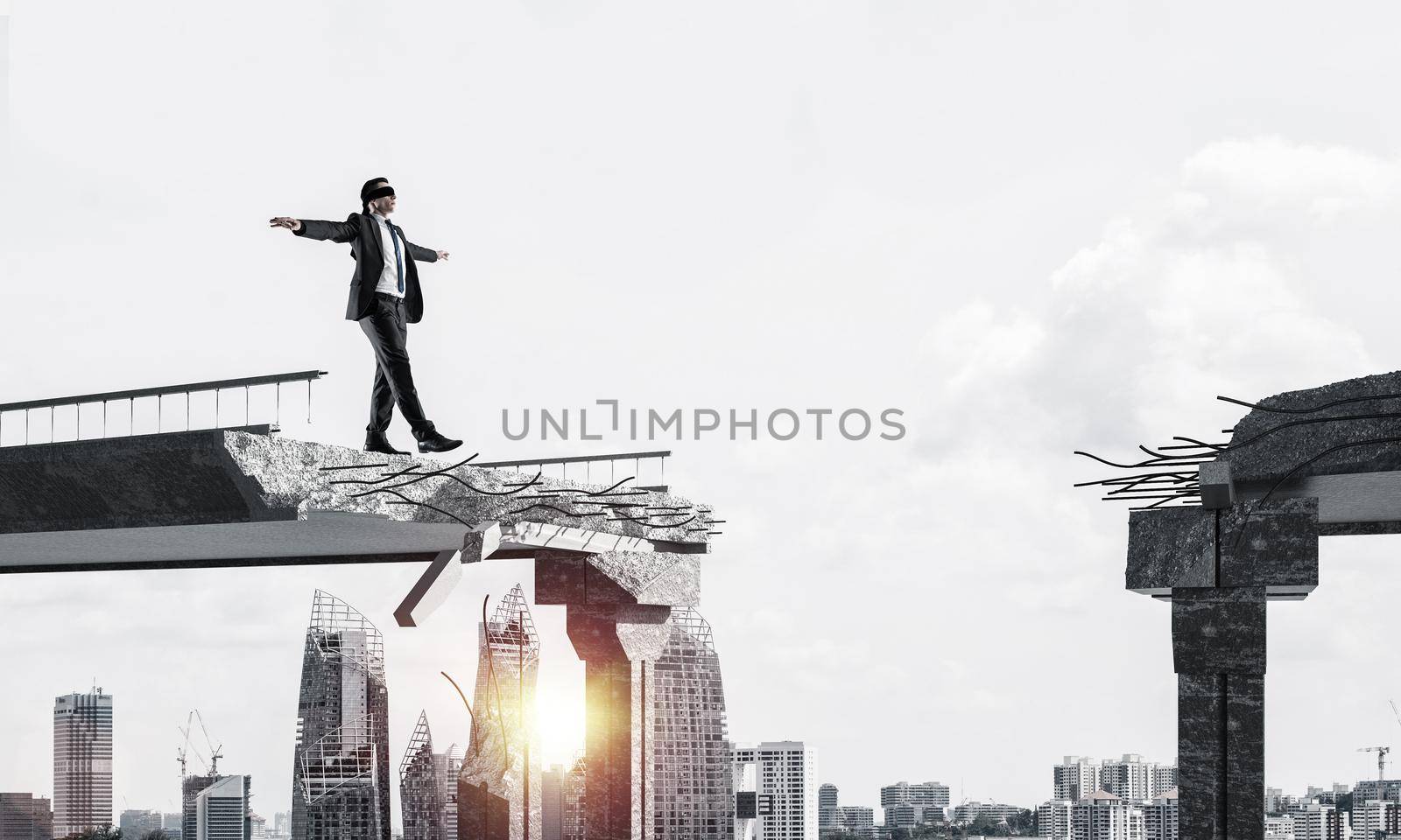 Businessman walking blindfolded on concrete bridge with huge gap as symbol of hidden threats and risks. Cityscape and sunlight on background. 3D rendering.