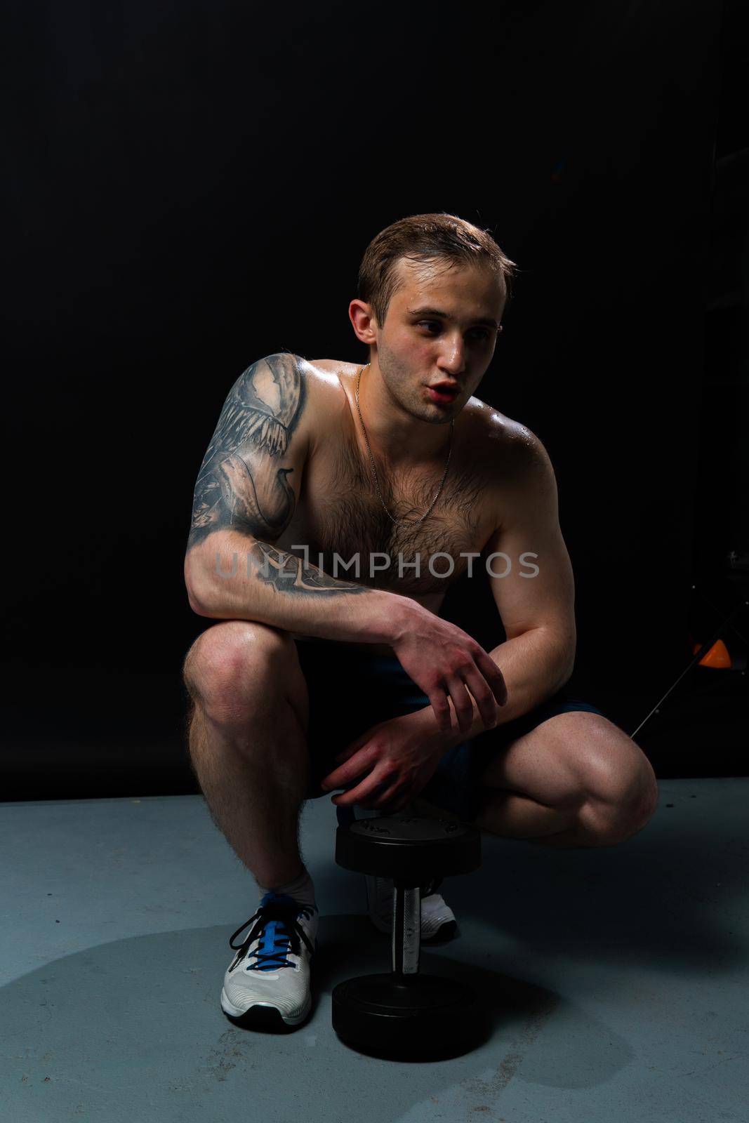 Man on black background keeps dumbbells pumped up in fitness muscle sexy body weight man hold powerful, person lifestyle. Young sportive power, guy fit