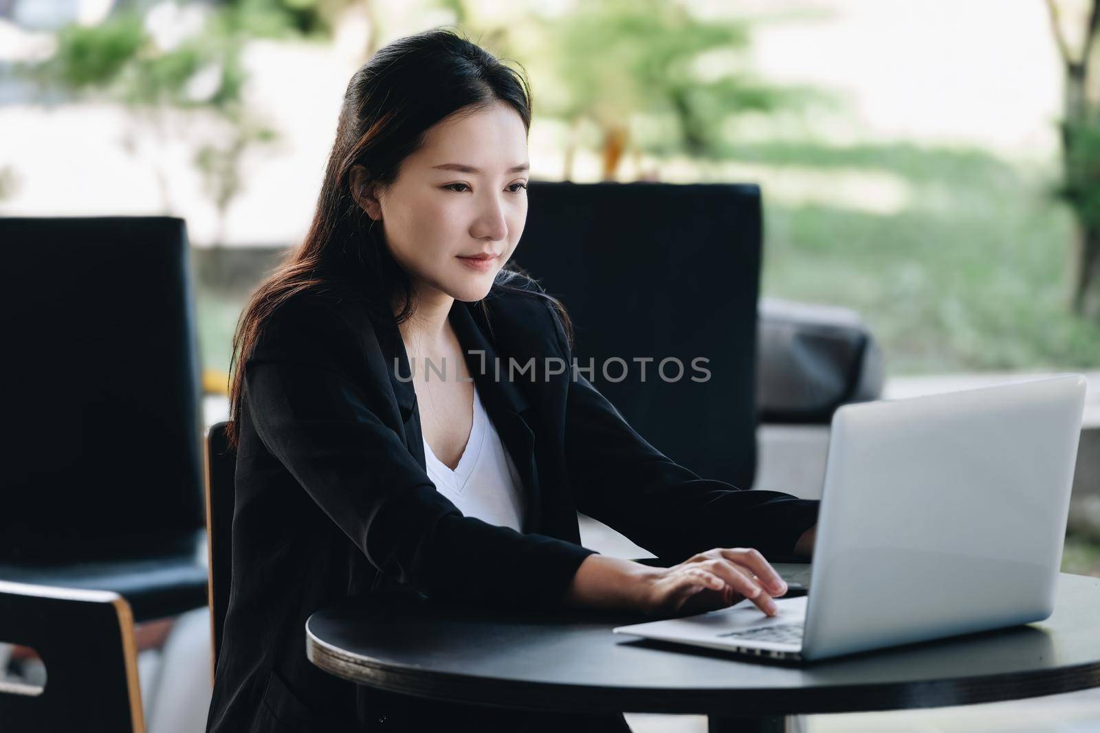 A female worker smiling happily while using a computer in the office