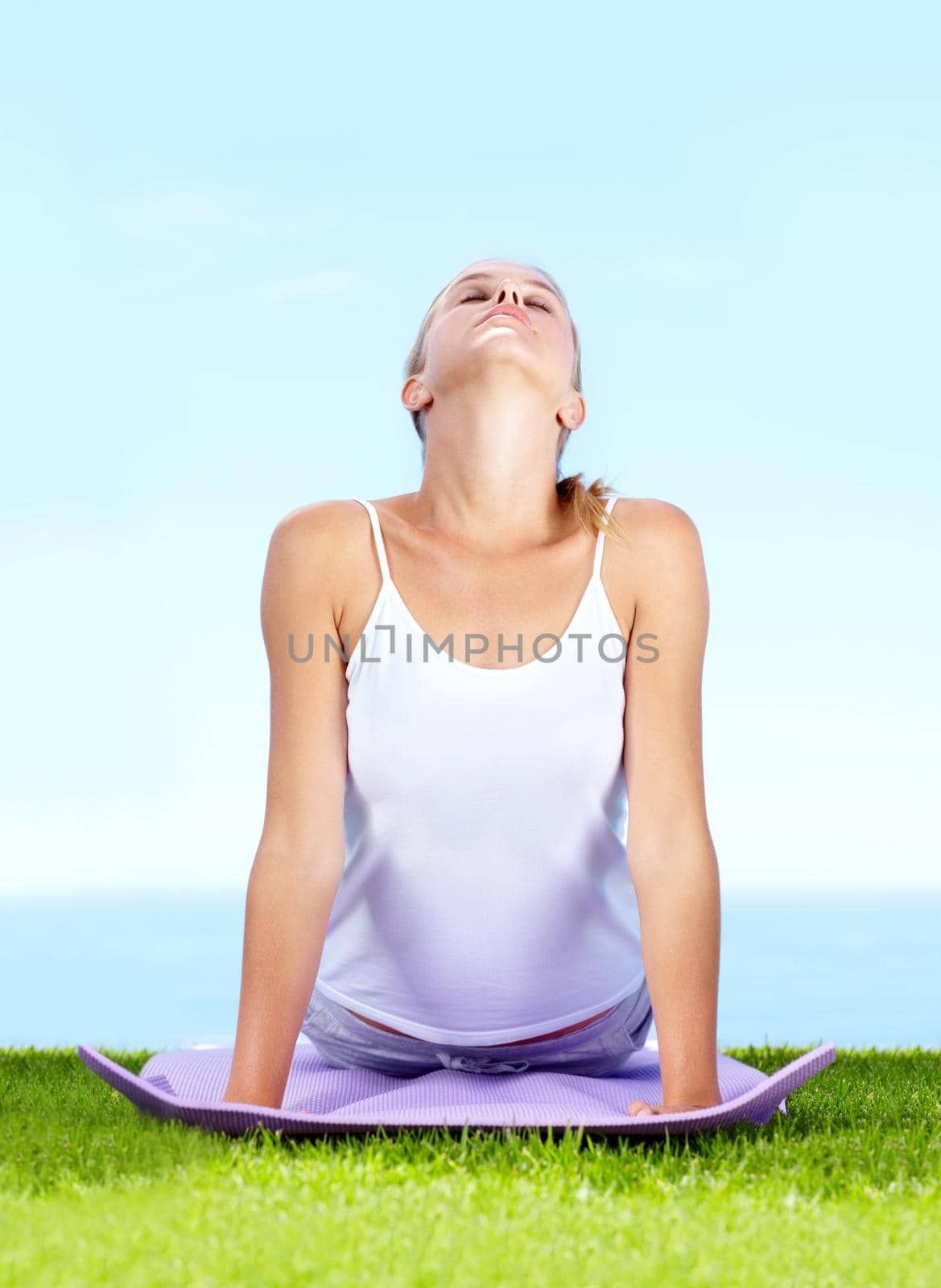 An attractive young woman doing yoga outdoors.