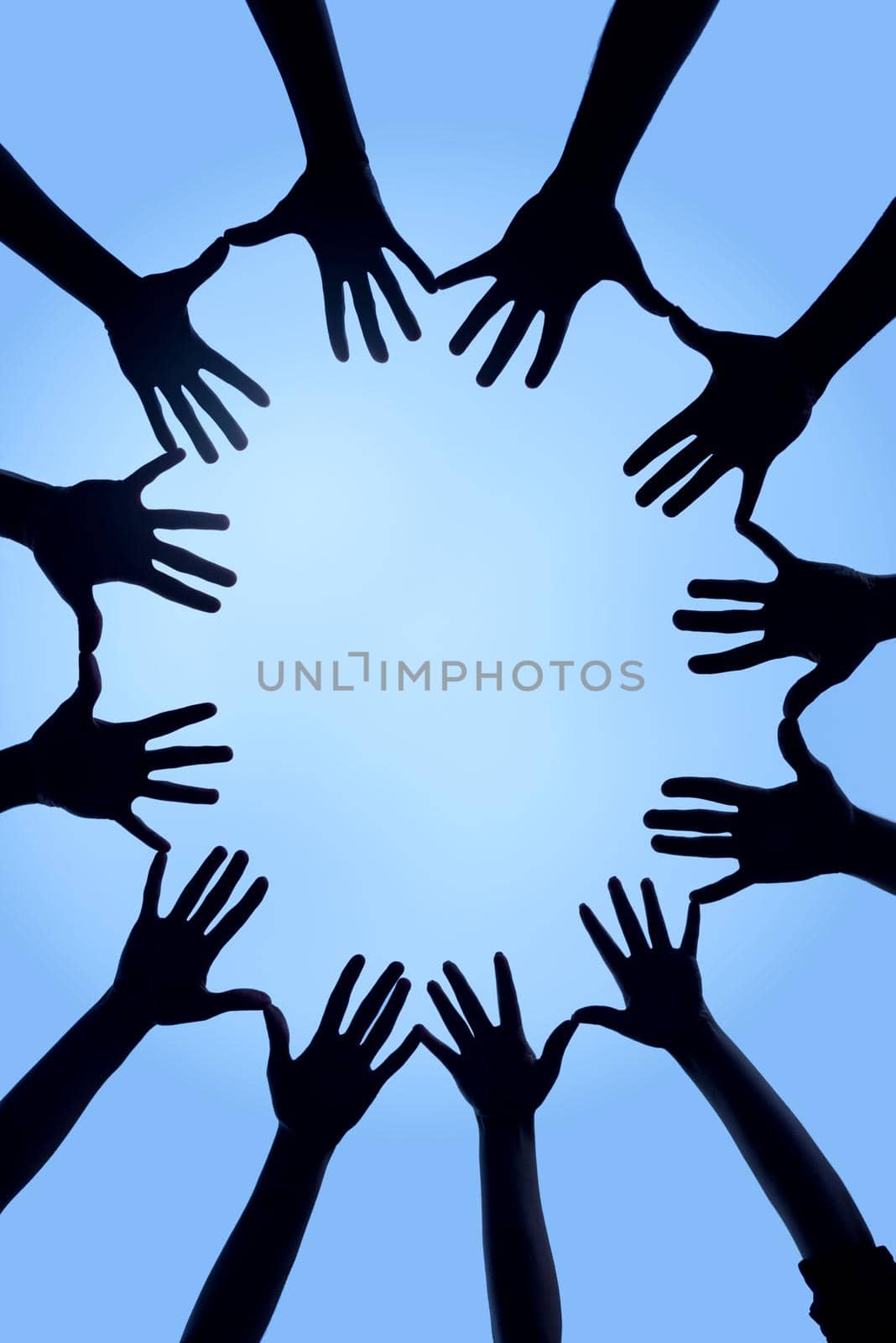 Uniting together. Cropped shot of a group of hands spread out together in a circle. by YuriArcurs
