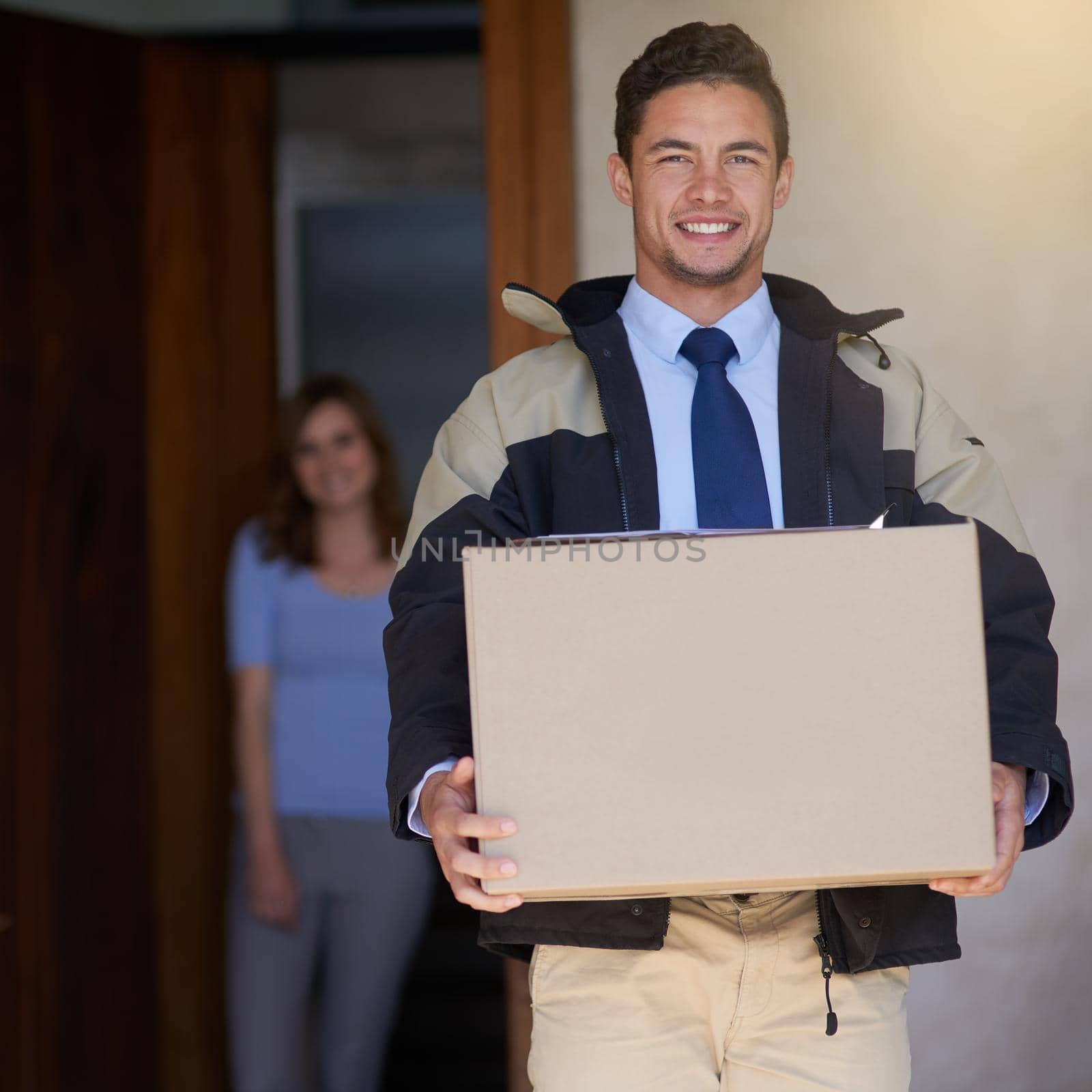 Shot of a handsome young delivery man making a delivery to a customer at her home.