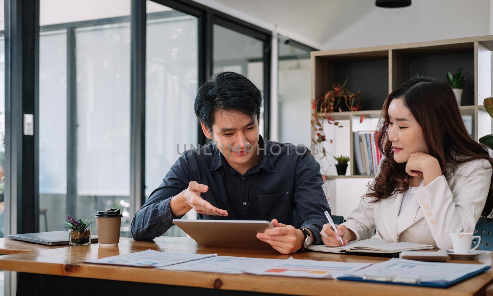 Asian business adviser meeting to analyze and discuss the situation on the financial report in the meeting room.Investment Consultant, Financial advisor and accounting concept