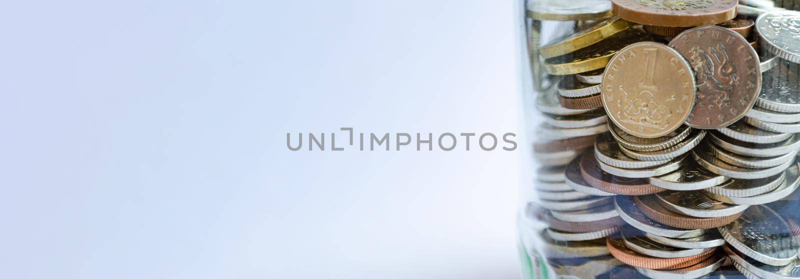 A glass jar full of coins, money related web banner with copy space, czech crowns