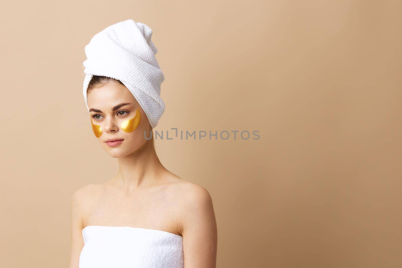 woman patches rejuvenation skin care fun after shower beige background. High quality photo