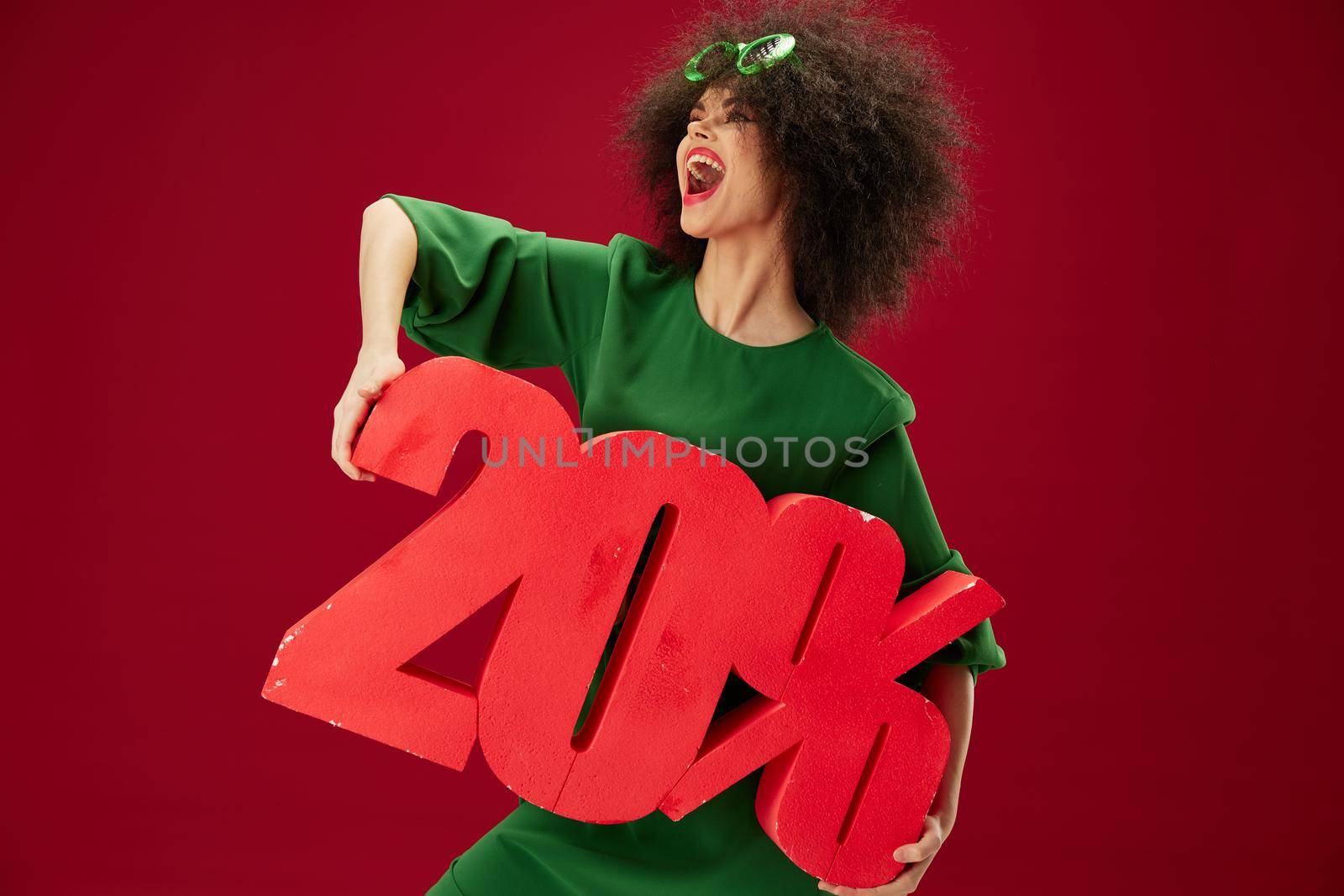 Positive young woman holding red twenty percent discount advertising color background unaltered. High quality photo