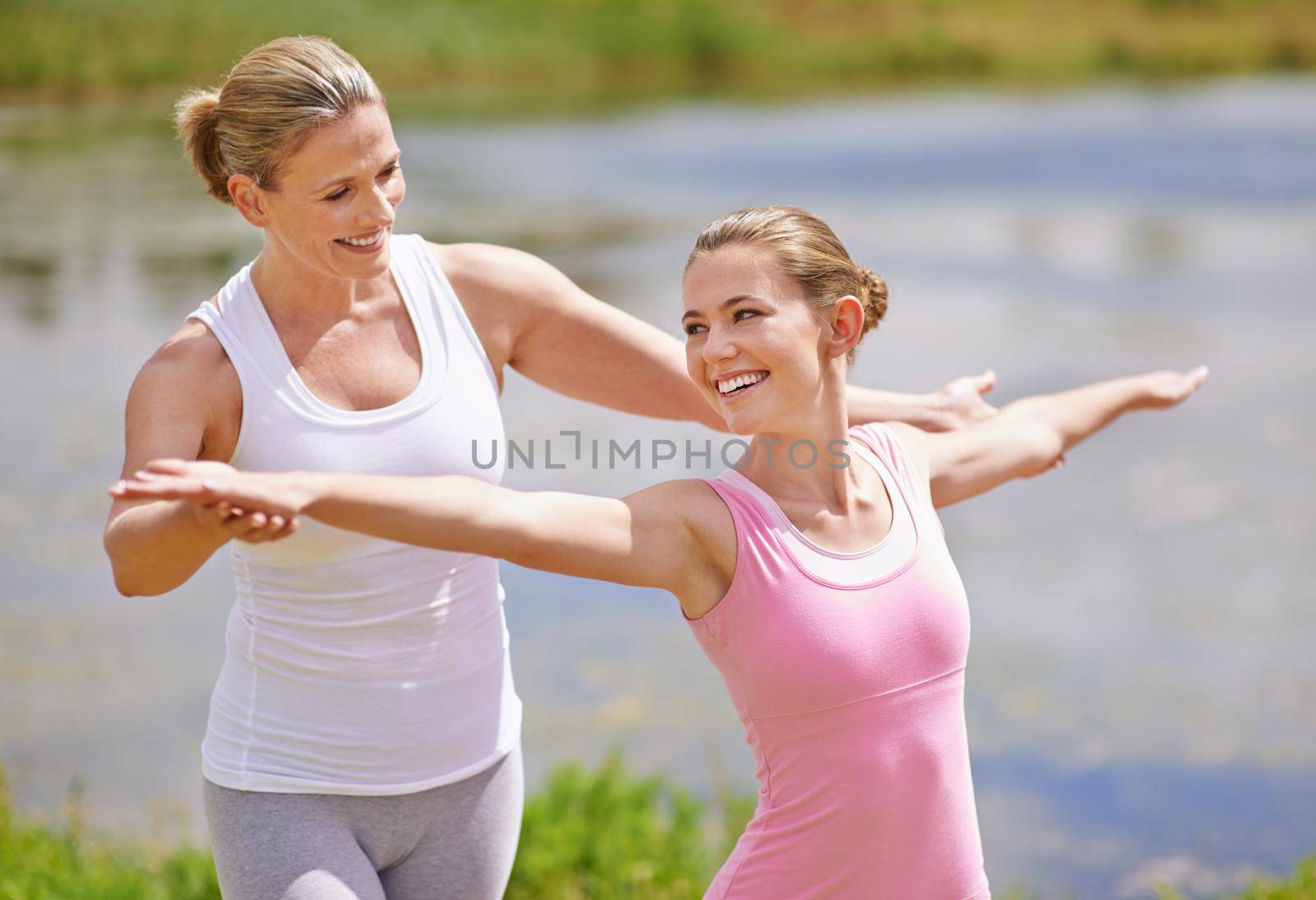 Shot of a young woman being instructed in an outdoor yoga class.