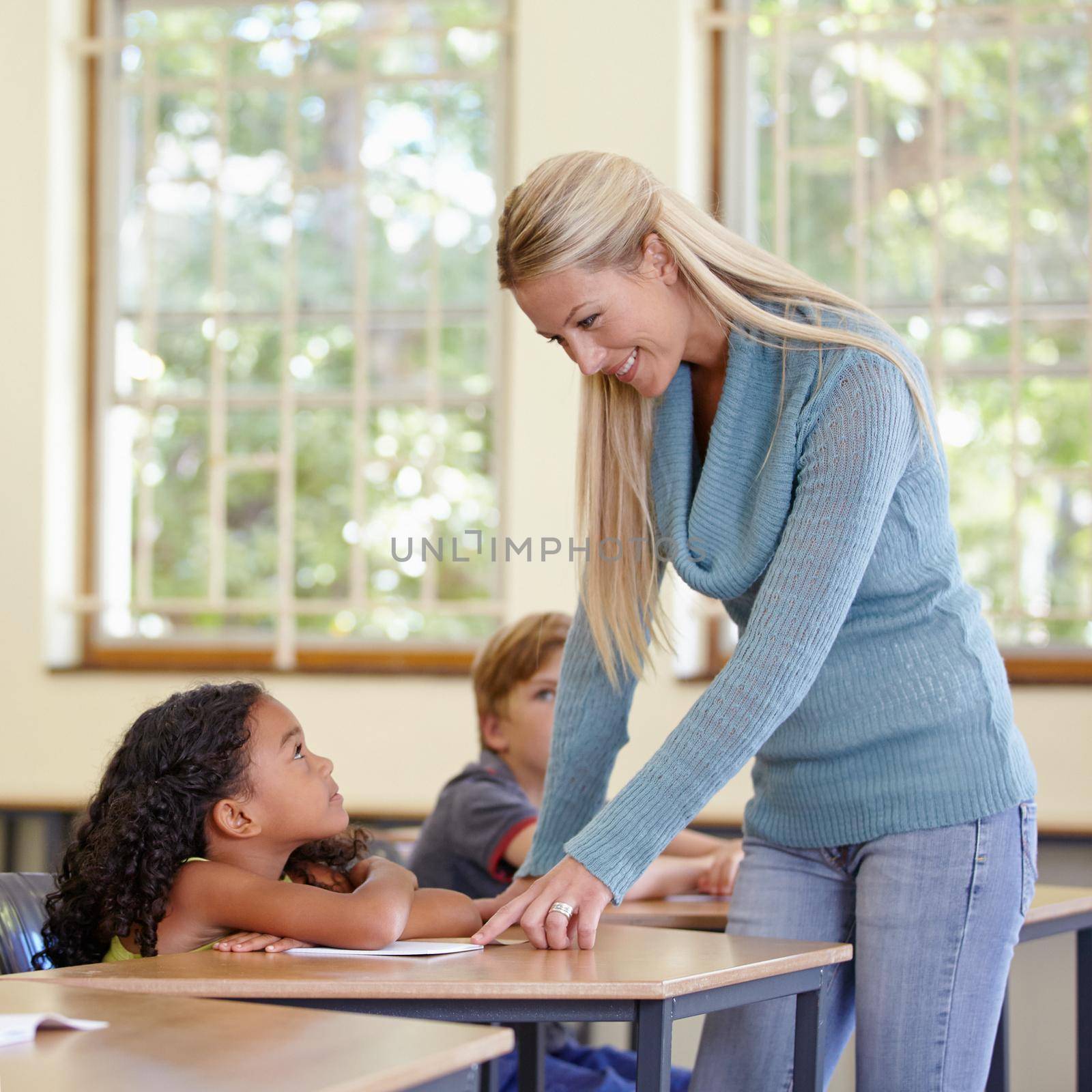 Enriching eager young minds. A young teacher in her classroom. by YuriArcurs