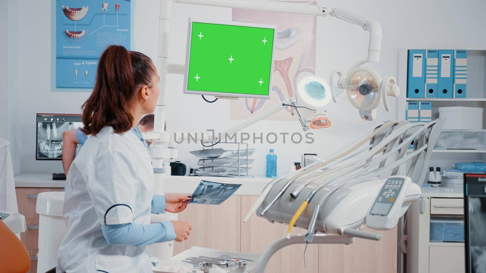 Dentist receiving teeth scan from man while looking at green screen by DCStudio