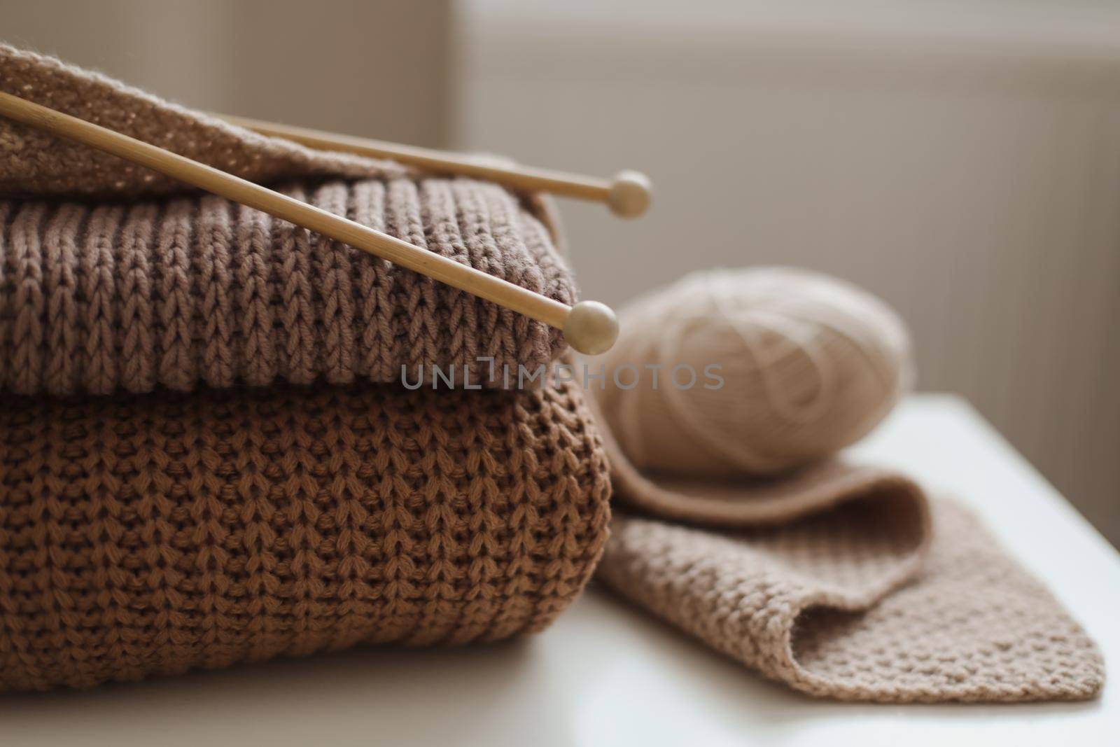 Knitting needles with threads, beige yarn. Hobby for women concept. Knitting accessories.