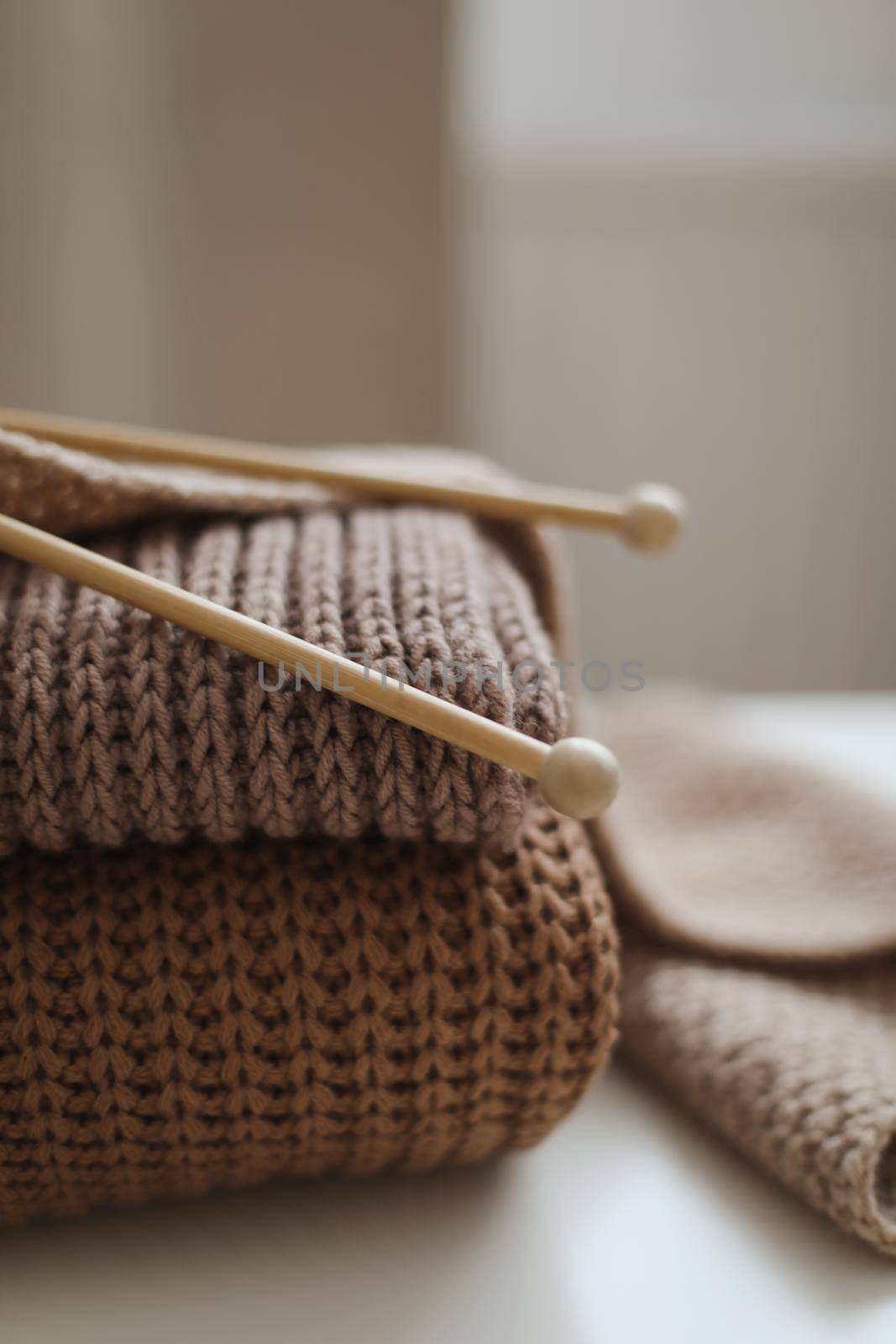 Knitting needles with threads, beige yarn. Hobby for women concept. Knitting accessories.