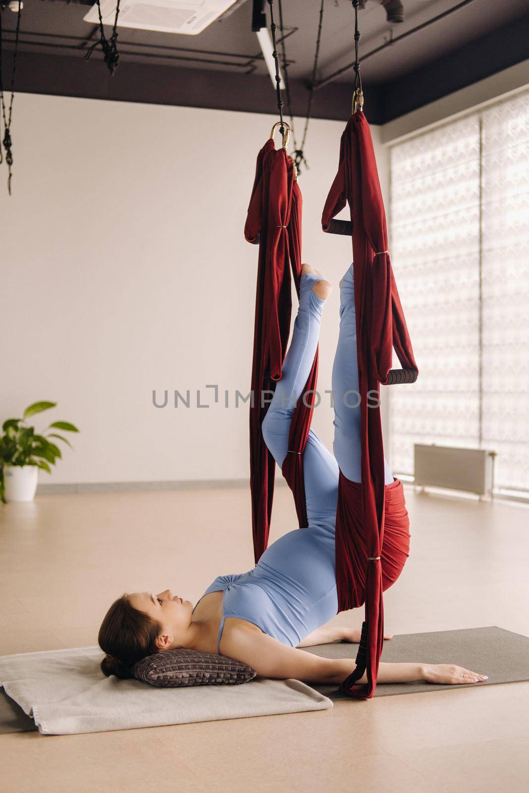 Pregnant girl. A woman does yoga on a hammock in the gym. The concept of a healthy lifestyle, Motherhood by Lobachad