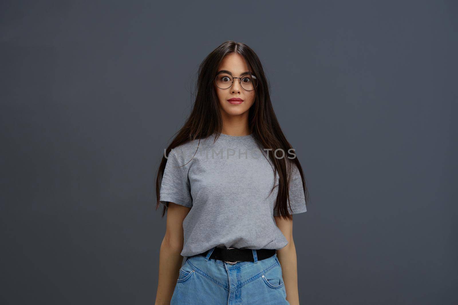 young woman glasses on face fashion lifestyle gray t-shirt studio model. High quality photo