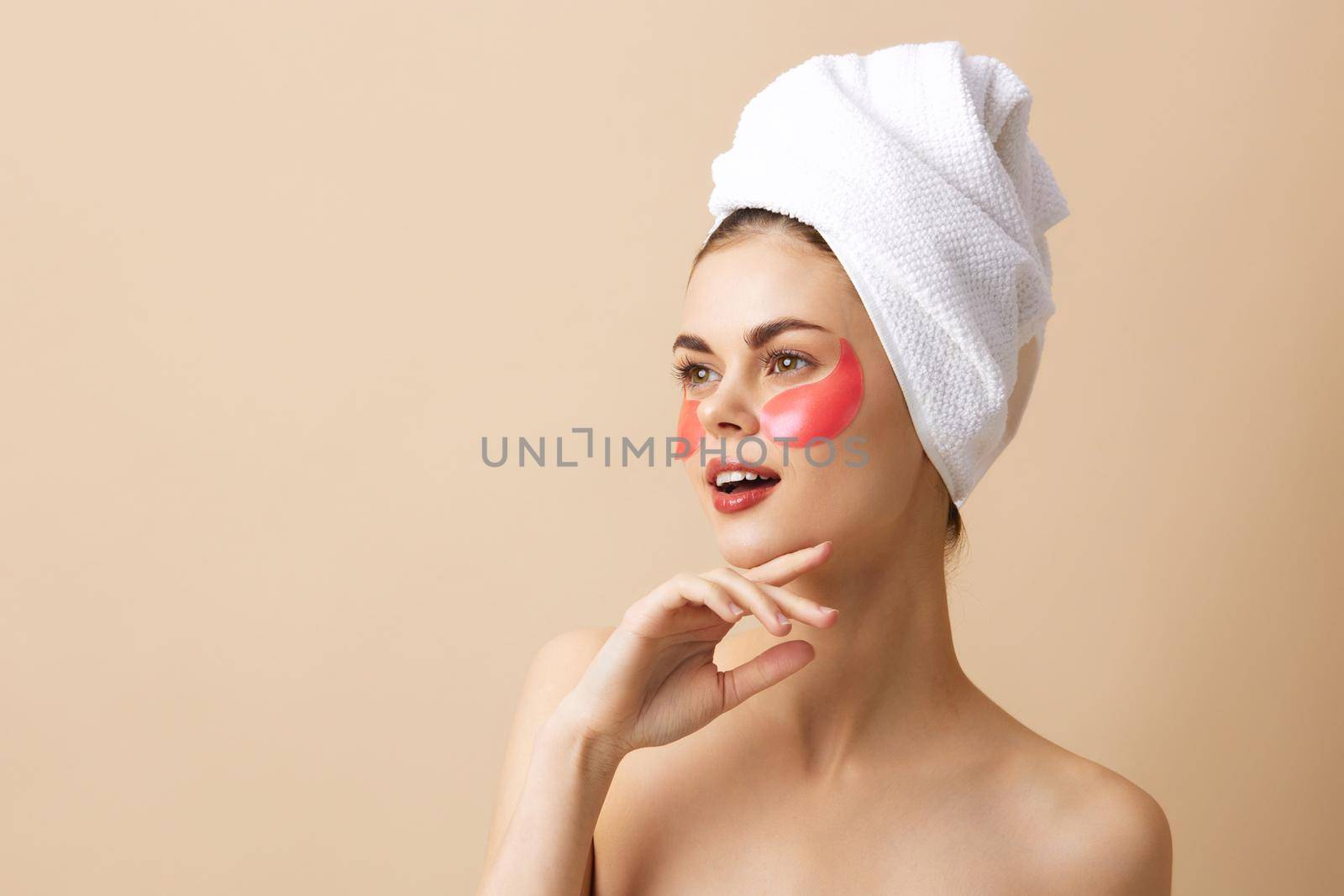portrait woman skin care face patches bare shoulders beige background. High quality photo