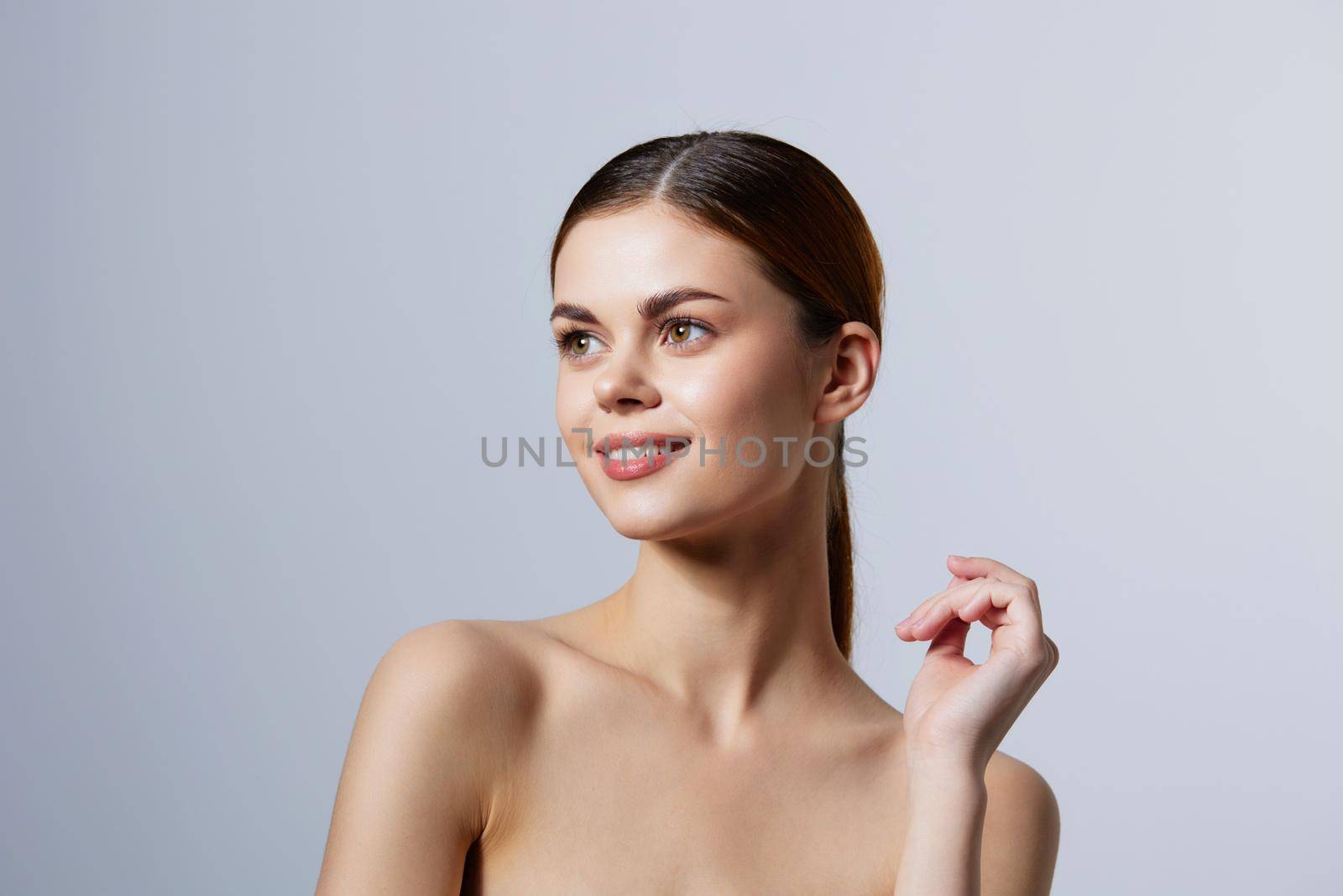 woman red hair bare shoulders cosmetics skincare light background. High quality photo