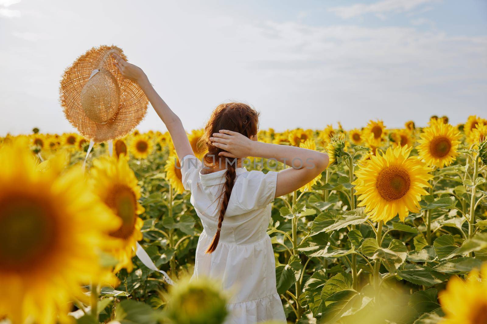 woman with pigtails in a white dress with raised hands a field of sunflowers by SHOTPRIME