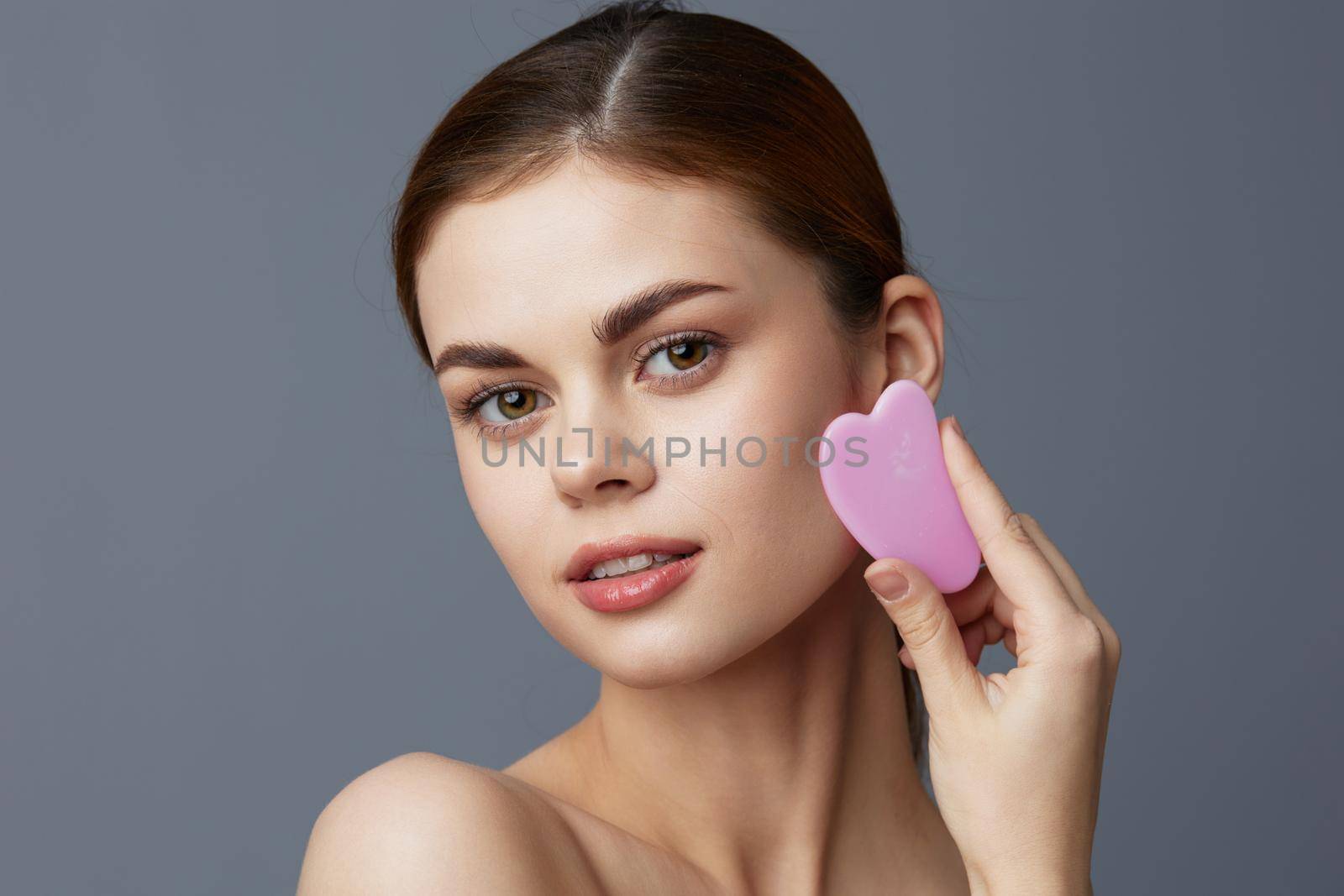 beautiful woman scraper gua sha facial care home facial massage isolated background by SHOTPRIME