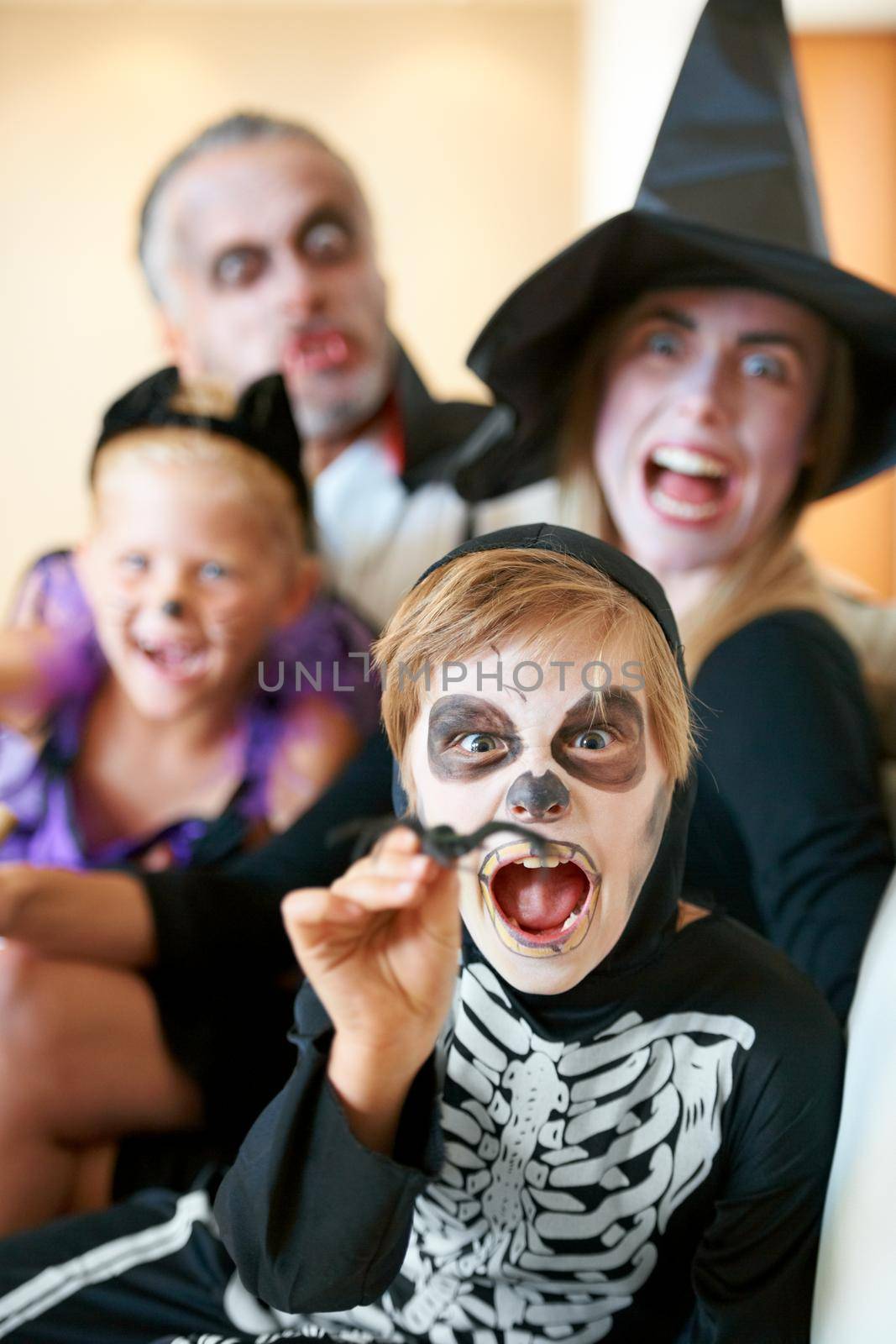 A cute family dressed up for Halloweamp039en screaming at the camera.