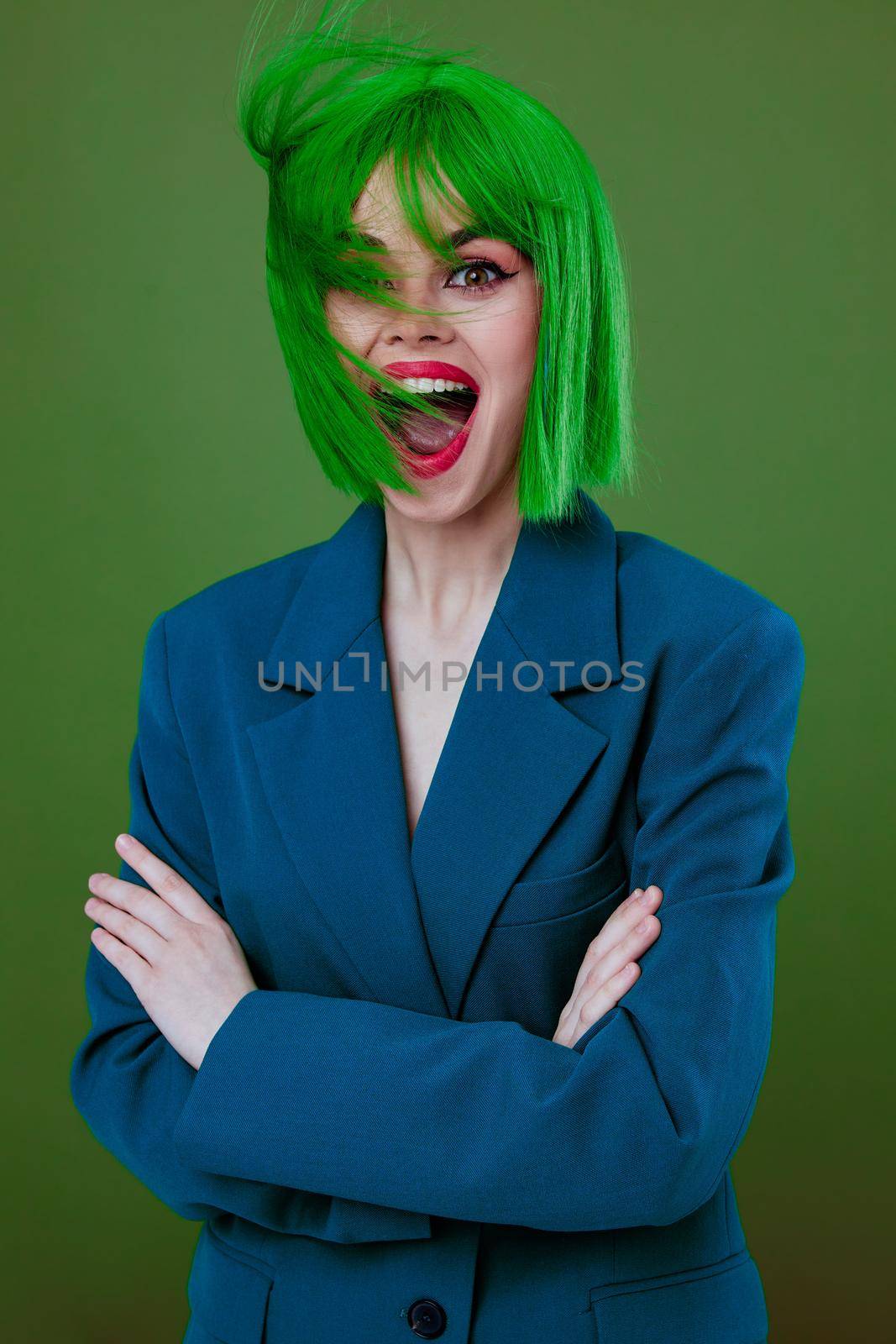 Beauty Fashion woman wearing a green wig blue jacket posing green background unaltered. High quality photo