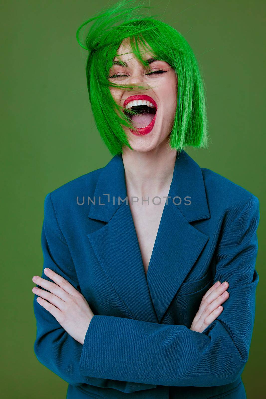 Portrait of a charming lady wearing a green wig blue jacket posing green background unaltered by SHOTPRIME