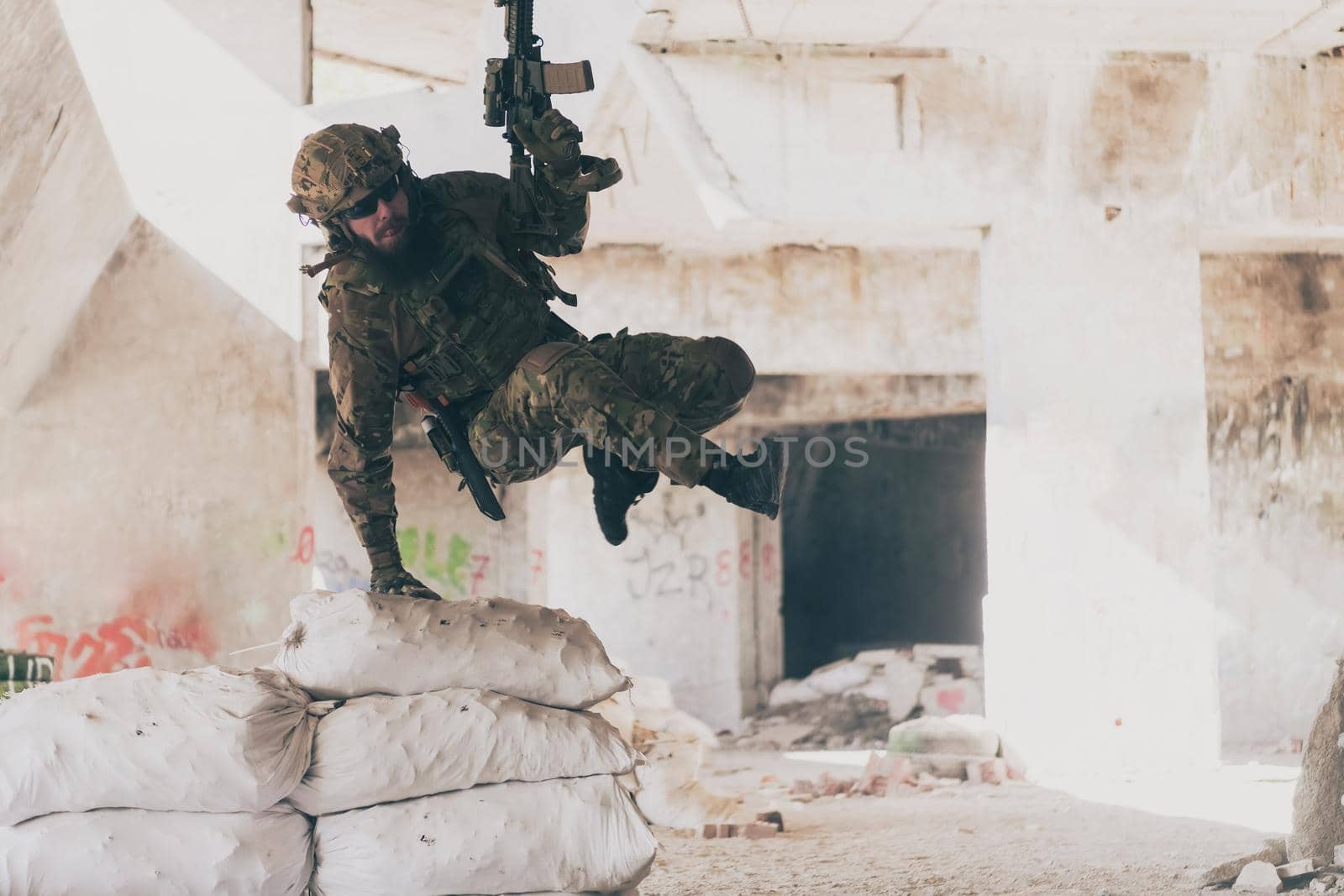 A bearded soldier in uniform of special forces in a dangerous military action in a dangerous enemy area. Selective focus by dotshock