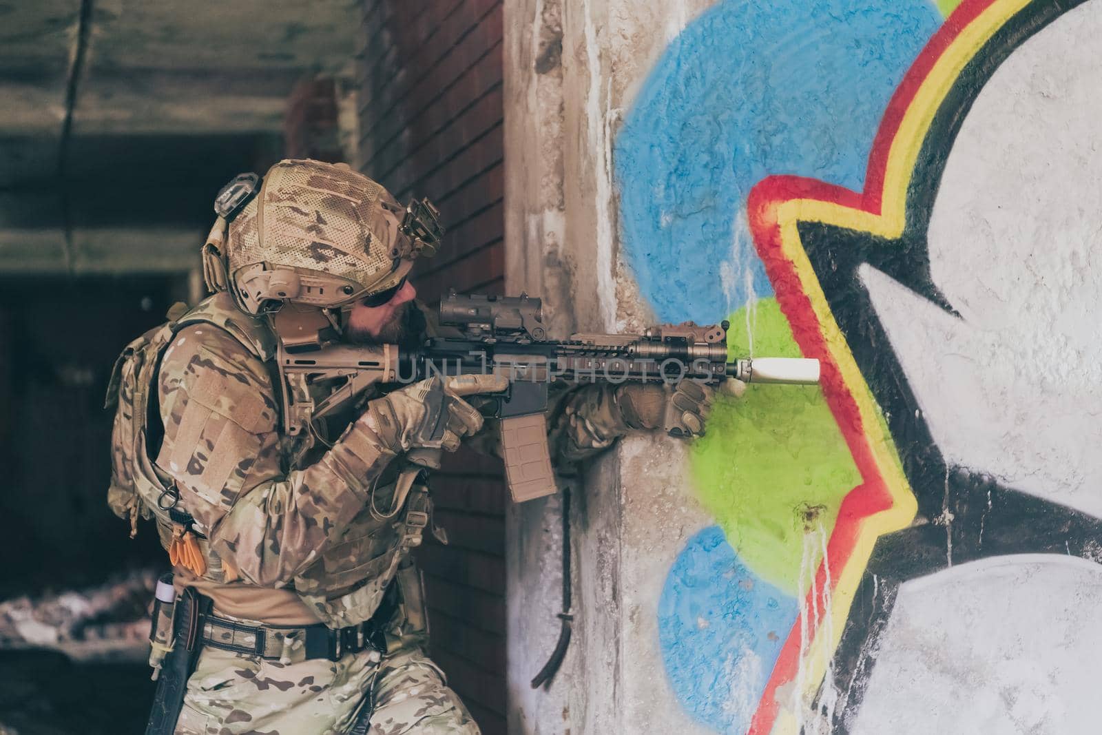 A bearded soldier in uniform of special forces in a dangerous military action in a dangerous enemy area. Selective focus by dotshock